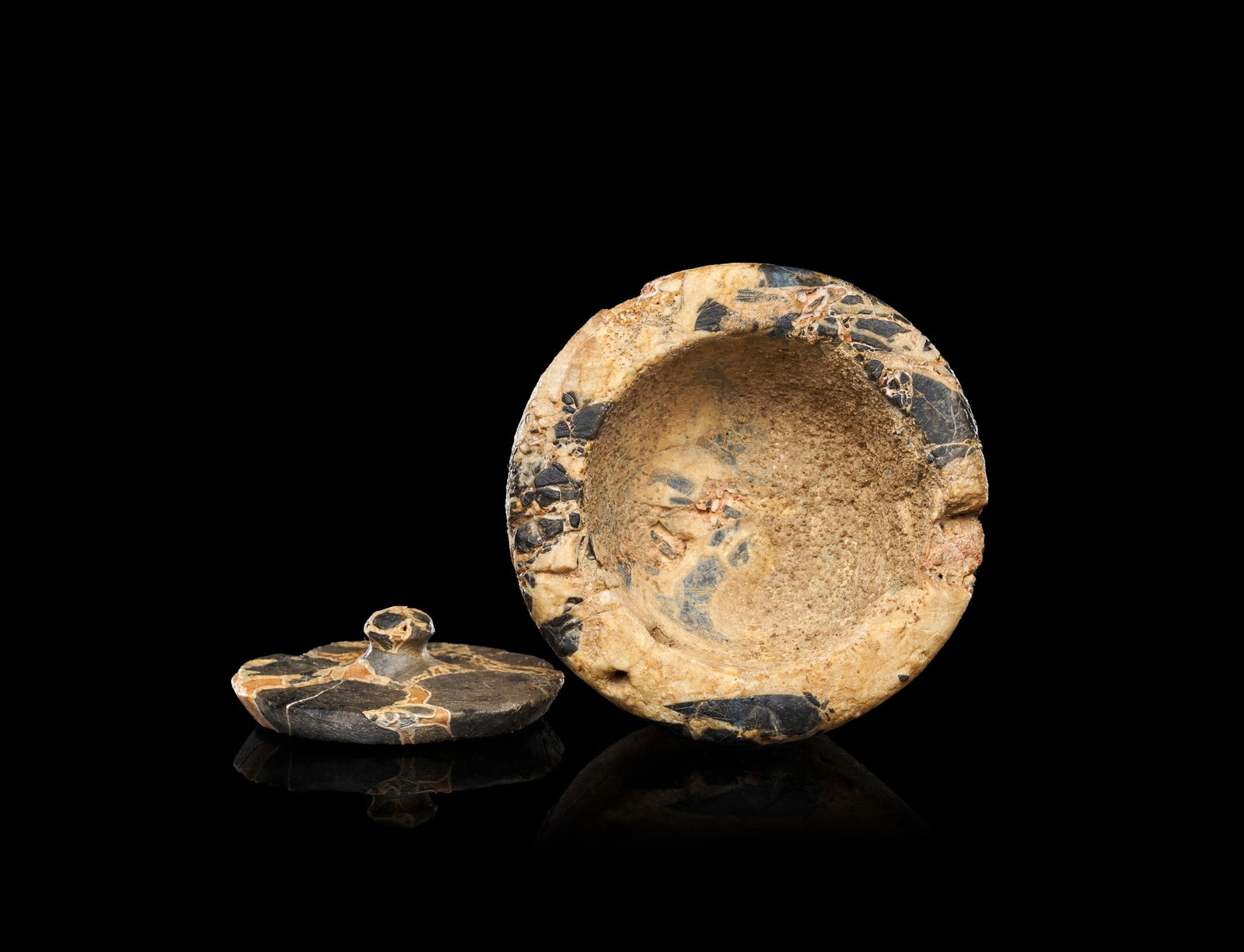 AN EXCEEDINGLY RARE MINOAN LIDDED BRECCIA PYXIS, CIRCA 1400-1200 B.C.: AN EXCEEDINGLY RARE MINOAN LIDDED BRECCIA PYXIS, CIRCA 1400-1200 B.C.Of squat cylindrical form, the vessel carved from a single block of variegated breccia with a flat, slightly recessed rim receiving