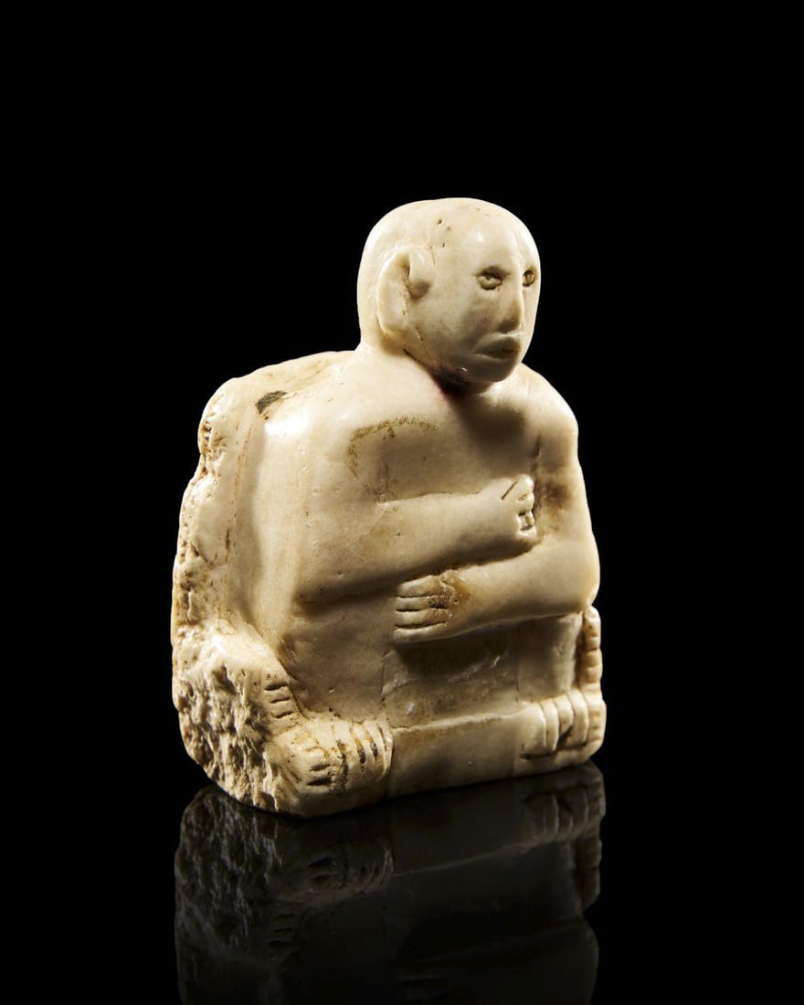 A SOUTH ARABIAN ALABASTER STELE Circa 2nd Century B.C.: A SOUTH ARABIAN ALABASTER STELE Circa 2nd Century B.C. Carved from pale alabaster with a softly lustrous surface, the stele presents the upper body of a seated figure emerging from a roughly rectangul