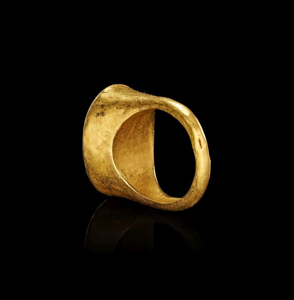 AN EXCEPTIONAL GREEK GOLD & AGATE INTAGLIO RING DEPICTING THE GODDESS DEMETER & BABY NURSING OVER: AN EXCEPTIONAL GREEK GOLD & AGATE INTAGLIO RING DEPICTING THE GODDESS DEMETER & BABY NURSING OVER WHEATThis exceptional Greek gold ring is set with an oval red agate intaglio, finely engraved with a s