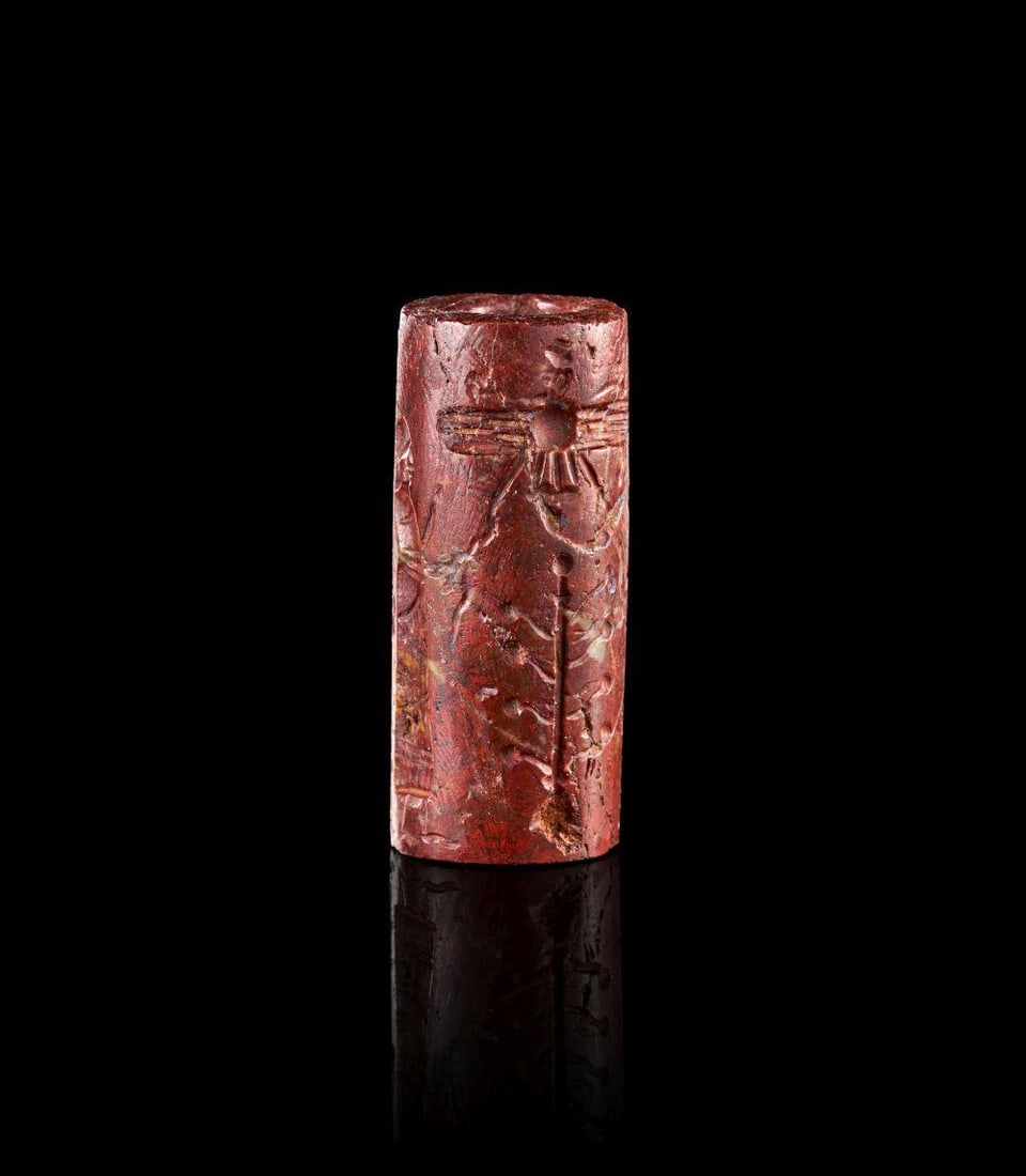 A FINE NEO-ASSYRIAN RED JASPER CYLINDER SEAL CIRCA 750-650 B.C.: A FINE NEO-ASSYRIAN RED JASPER CYLINDER SEAL CIRCA 750-650 B.C. A fine Neo-Assyrian red jasper cylinder seal, carved in a deep reddish-brown stone with darker and lighter natural inclusions. The cylin