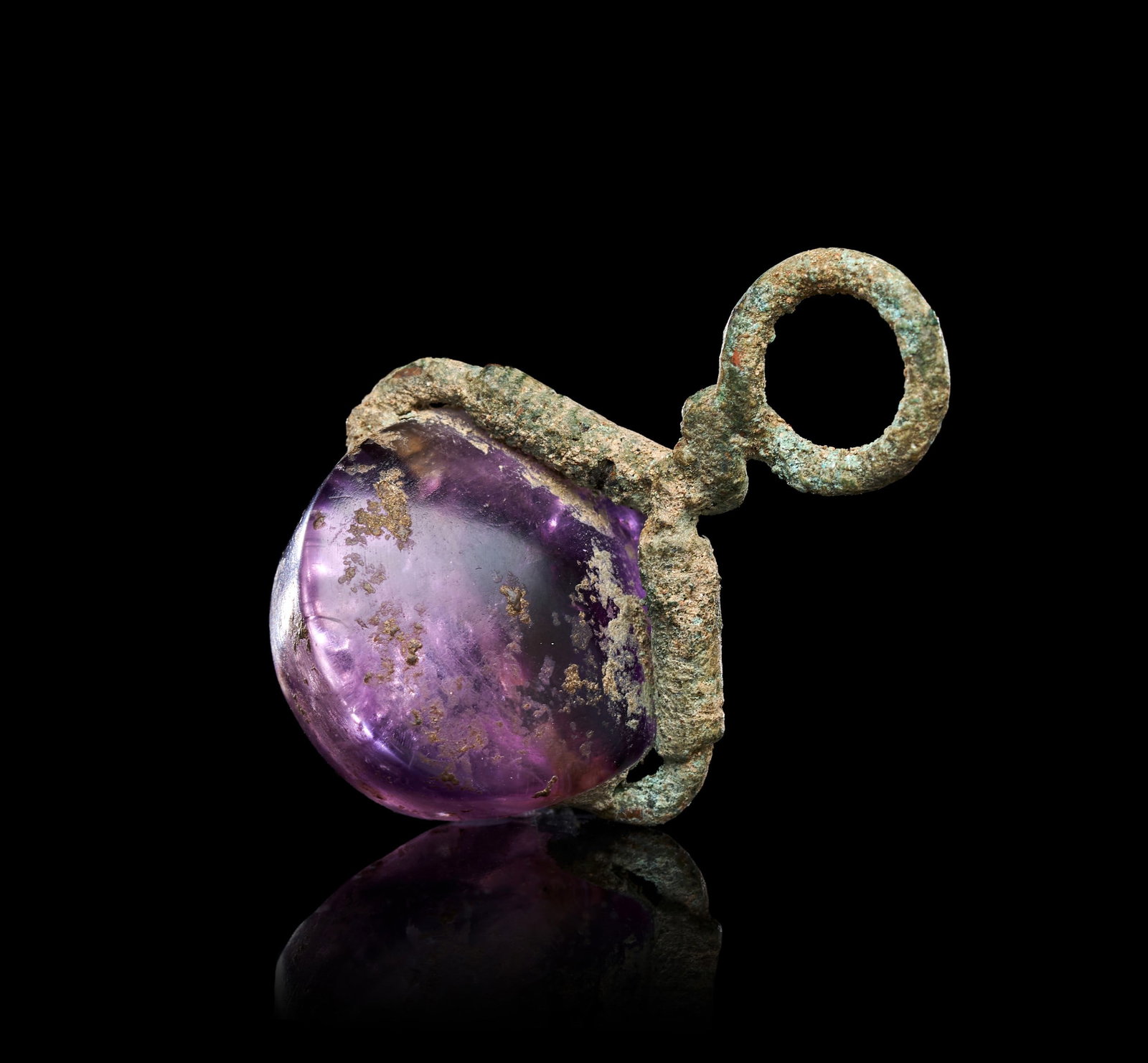 A GREEK AMETHYST SCARABOID INTAGLIO OF A SPHINX SET IN A BRONZE SWIVEL, CIRCA 4TH-3RD CENTURY B.C.: A GREEK AMETHYST SCARABOID INTAGLIO OF A SPHINX SET IN A BRONZE SWIVEL, CIRCA 4TH-3RD CENTURY B.C.The domed amethyst scaraboid is set transversely within a corroded bronze swivel mount, the hoop termi