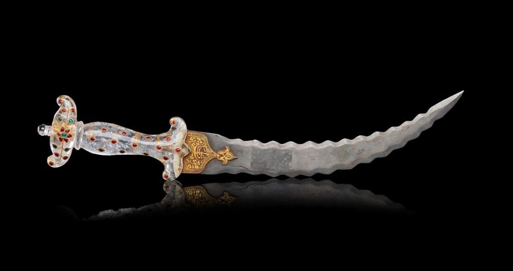 A MUGHAL GEM SET ROCK CRYSTAL HILTED DAGGER WITH GOLD DAMASCENED BLADE, 19TH CENTURY, INDIA: A MUGHAL GEM-SET ROCK CRYSTAL HILTED DAGGER WITH GOLD-DAMASCENED BLADE, INDIA, 19TH CENTURY The dagger of characteristic Mughal form, the curved single-edged steel blade of wavy or flamboyant profile 