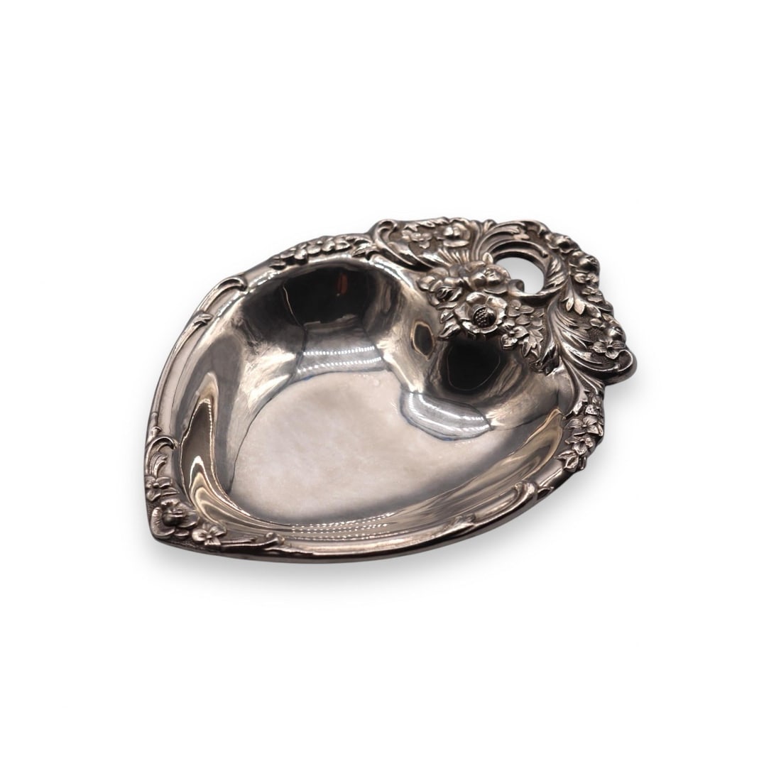 Leonard Silver Heart Shaped w/ Floral Design Silverplate Trinket Dish: Leonard silverplate heart-shaped trinket dish featuring an elegant floral design along the edge, adding a romantic touch to its timeless appeal. Measuring 8” inches long, it is perfect for holdi