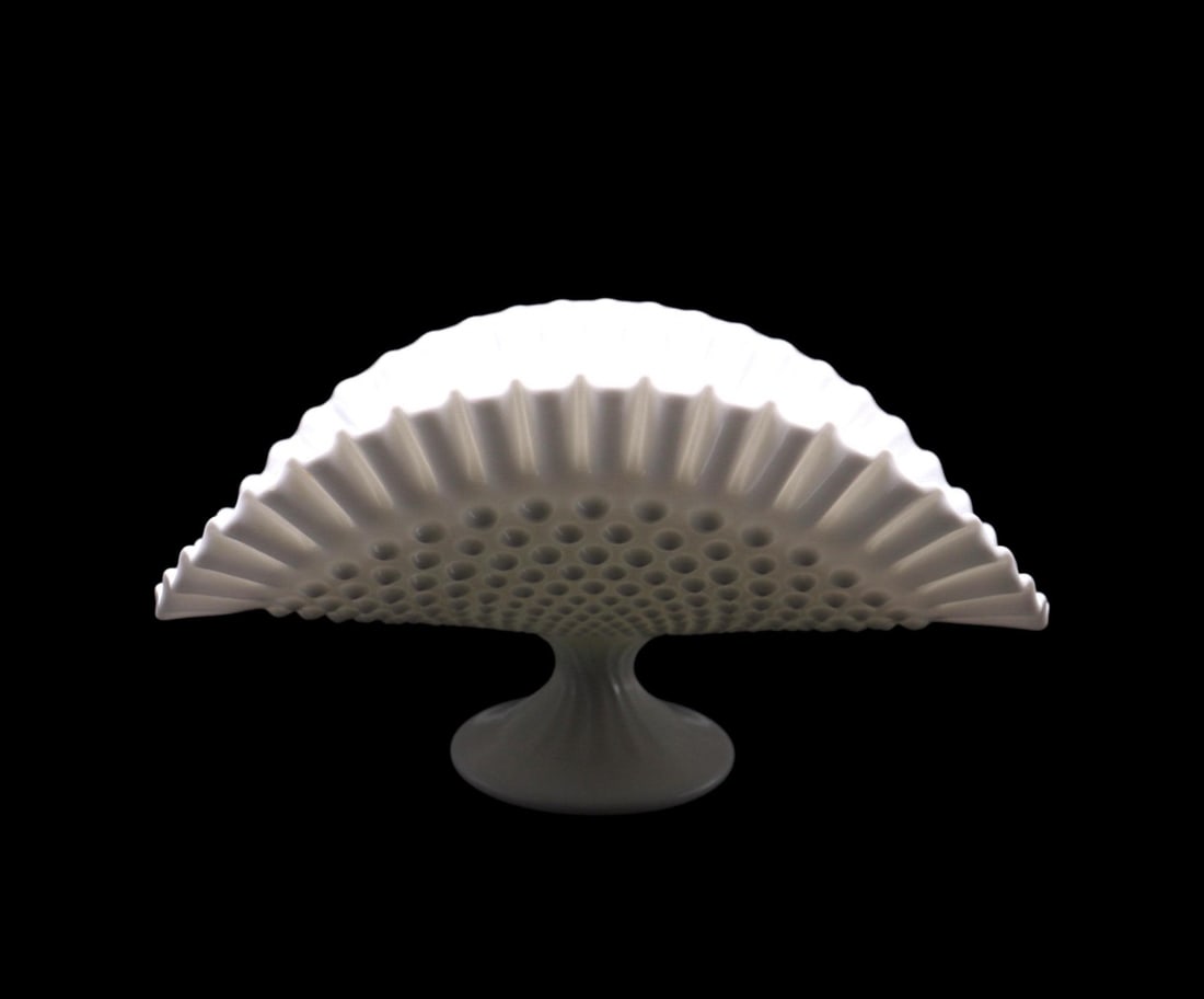 Fenton Art Glass White Hobnail Banana Stand: Fenton Art Glass white hobnail banana stand featuring a gracefully flared design with a textured hobnail pattern and scalloped edges. Measuring 12 1/2 inches long and 6 3/8 inches tall, it is in excel