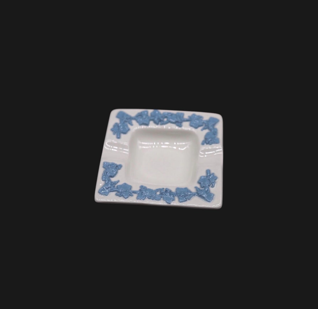 Wedgwood Lavender on Cream Color Embossed Queensware Ashtray: Wedgwood Queensware ashtray featuring a cream-colored body with a lavender blue floral embossed design near the rim. Measuring 3 inches wide, it features the classic grape design. The ashtray has no d