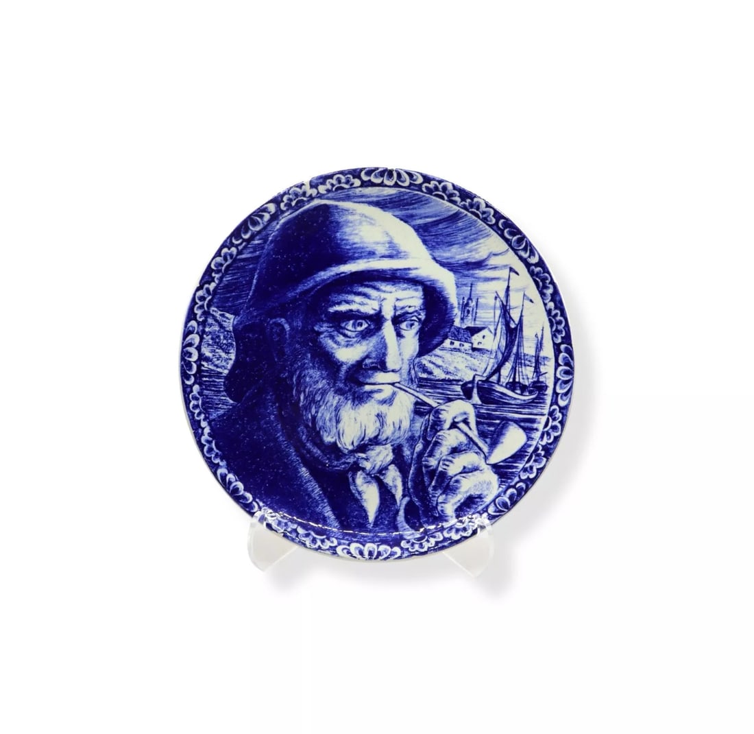 Boch Frères La Louvière Delft Sailor w/ Pipe Wall Plate: Boch Frères La Louvière Delft wall plate, featuring a striking blue and white design of a sailor with a pipe, set against a maritime background. Measuring 10 inches in diameter, this beautifully det
