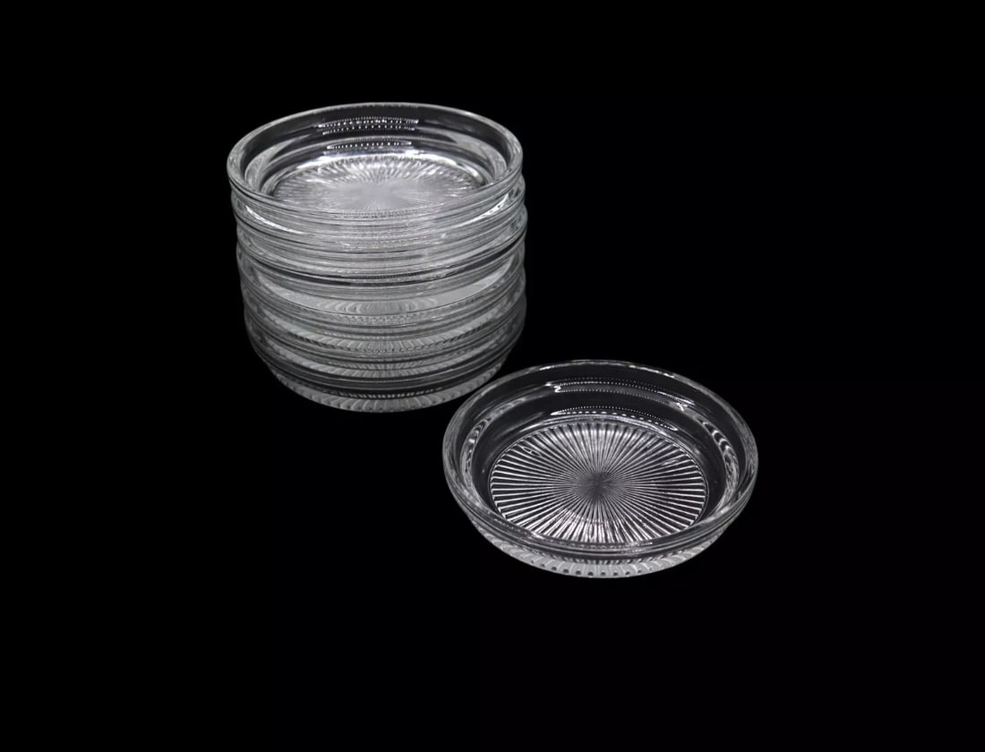 (7) Brockway Glass Co. “Carousel” Clear Glass Coasters: Set of seven vintage clear glass coasters from Brockway Glass Co.'s “Carousel” line, each measuring 3 3/4 inches in diameter. The design features a radiant starburst pattern on the base adding