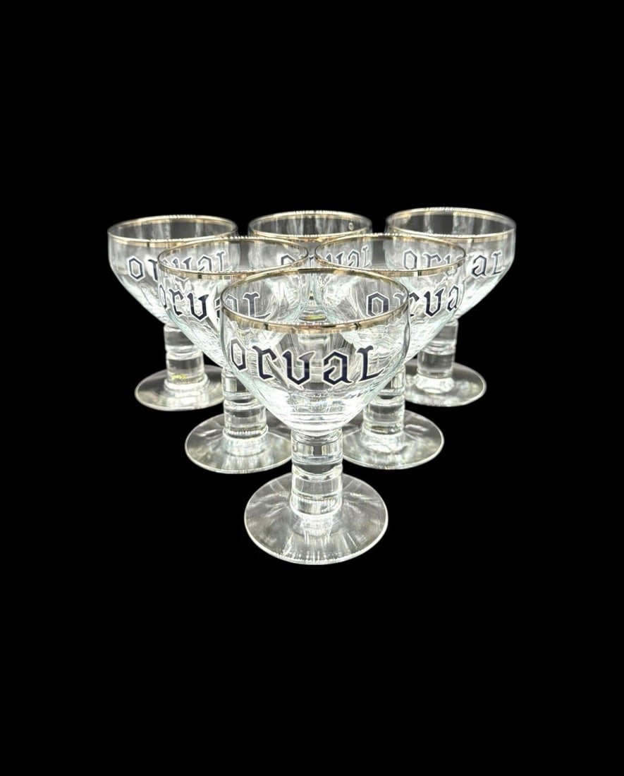 Set Of 6 Orval Trappist Belgian Ale Silver Rimmed Chalices: This set of 6 Orval Trappist Belgian Ale silver-rimmed chalices is a rare and collectible piece for beer enthusiasts and collectors. Made in Belgium, these vintage beer glasses feature a classic chali