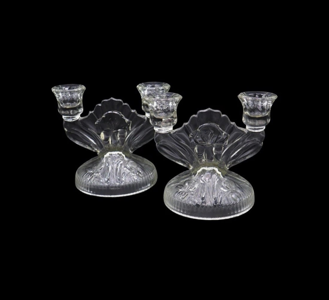 (2) Jeannette “Iris Clear” Pressed Glass Double Light Candlesticks: Jeannette "Iris Clear" pressed glass double light candlesticks featuring a stunning embossed iris design with a ribbed pedestal base. Standing 5 3/8 inches tall, it combines elegance with functionalit