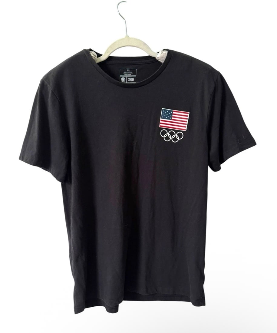 Men’s Team USA Apparel Olympic Tokyo 2020 Black Tshirt - Size L: The product is a Men's Team USA Apparel Olympic Tokyo 2020 Black T-shirt in size L. This official Team Apparel shirt features a design celebrating the USA Olympic team, making it a stylish and patriot