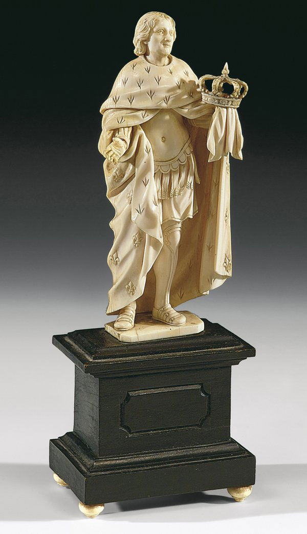 SOVRANO FRANCESE DELLA FINE DEL XVIII SECOLO: scolpito in avorio; base in legno ebanizzato, h. cm. 22 compl. Ritratto stante, il sovrano, dai capelli ondulati bipartiti, indossa un ampio mantello decorato con i gigli francesi a coprire la tunica