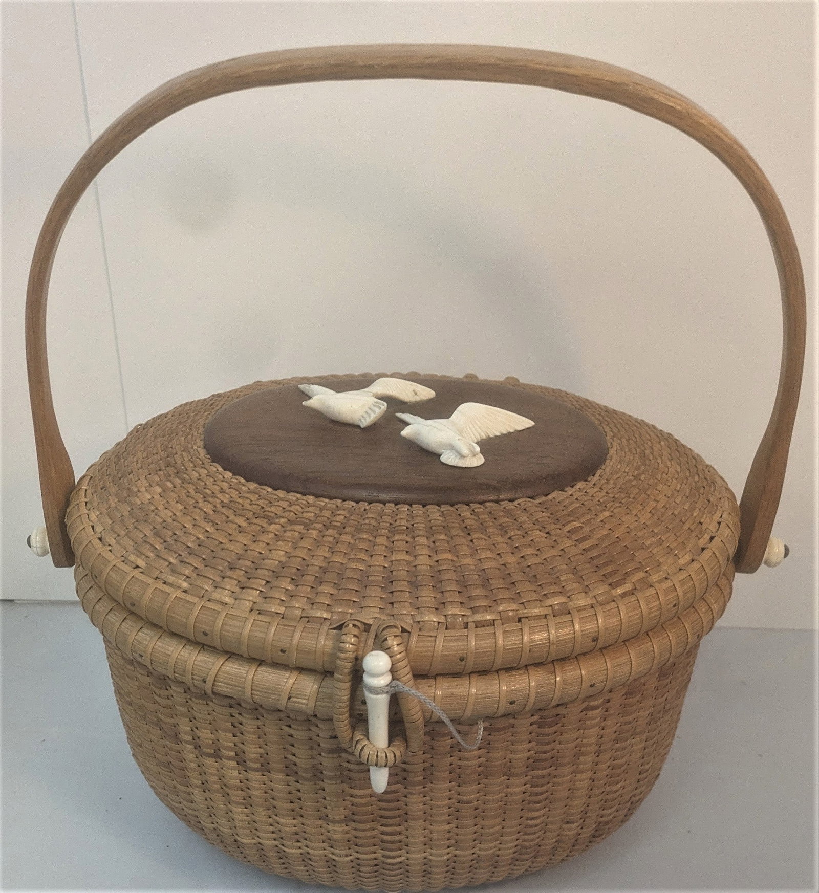 Large 1980 Nantucket Hand Woven Basket with carved whale bone accessories: Large 1980 Nantucket Hand Woven Basket with carved whale bone accessories, 2 birds, 2 handle knobs & basket lid fastener. Engraved-Signed on bottom – Chin Nantucket. Inside a plaque dated July 1980.