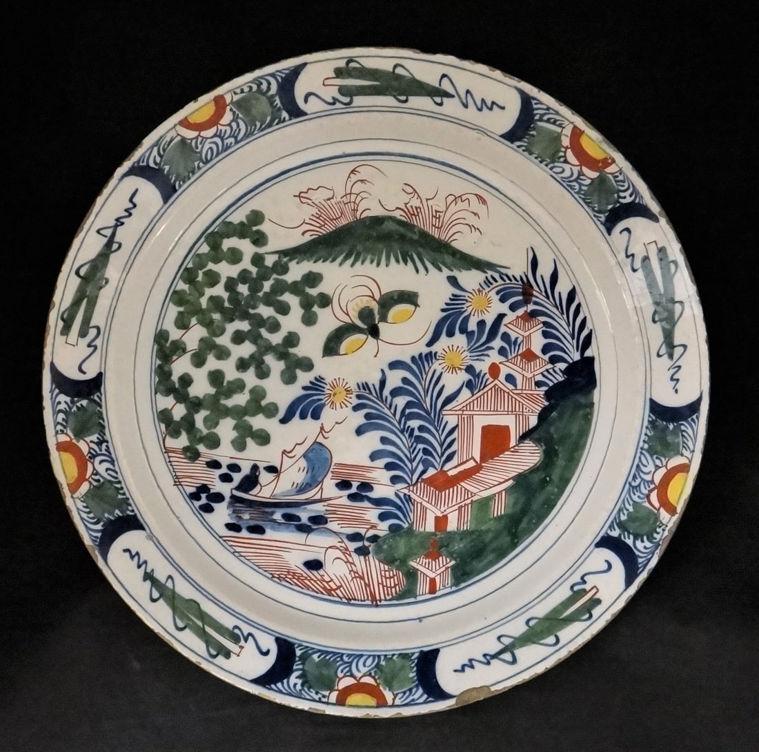 18th c. English Delft charger w/polychrome glaze: Mid-18th cent. English Delft charger with a beautiful polychrome glaze of a lake scene & sailboat. Approx 13 ¾” dia. 2” tall.