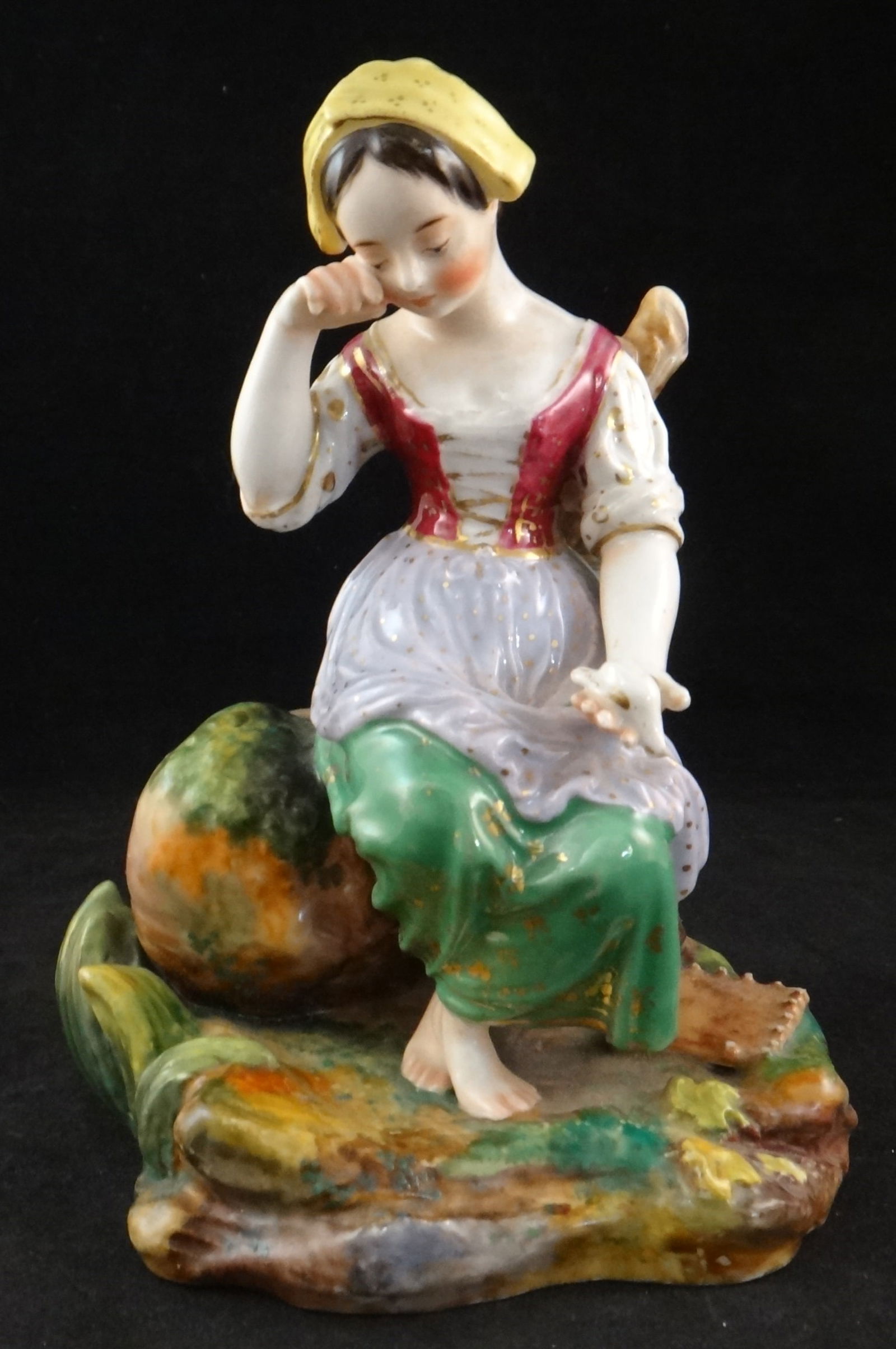No. European Porcelain Figure- Seated Girl -: 19th cent. Northern European Porcelain Figure of a Seated Girl Crying Holding a White Dove. Hand Painted with painted 23k gold on her dress. 6 ½” tall, 5” wide. Makers initials on t
