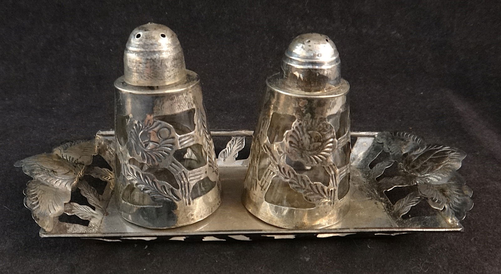Mid-c Mexican Tooled Sterling Tray & Sterling Overlay Glass Salt & Pepper.: Mid-cent Mexican Tooled Sterling Tray & Sterling Overlay Glass Salt & Pepper. Marked MG Atcher . 39.Tray measures 5 ¾” x 2 ½”. Salt & Pepper 2 ½” tall. Total wt.