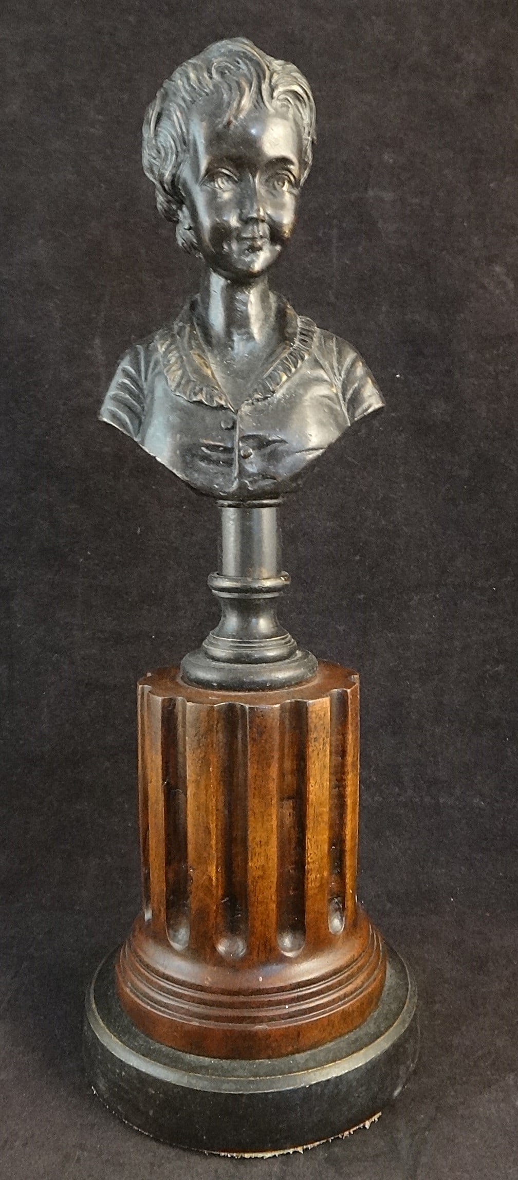 Antique French Bronze Bust of a Boy with Ruffled Shirt: Antique French Bronze Bust of a Boy with Ruffled Shirt. Mounted on a bronze column on a carved classical fluted mahogany column, brown patinaed bronze circular base. Late 19th cent. 12” tall ove
