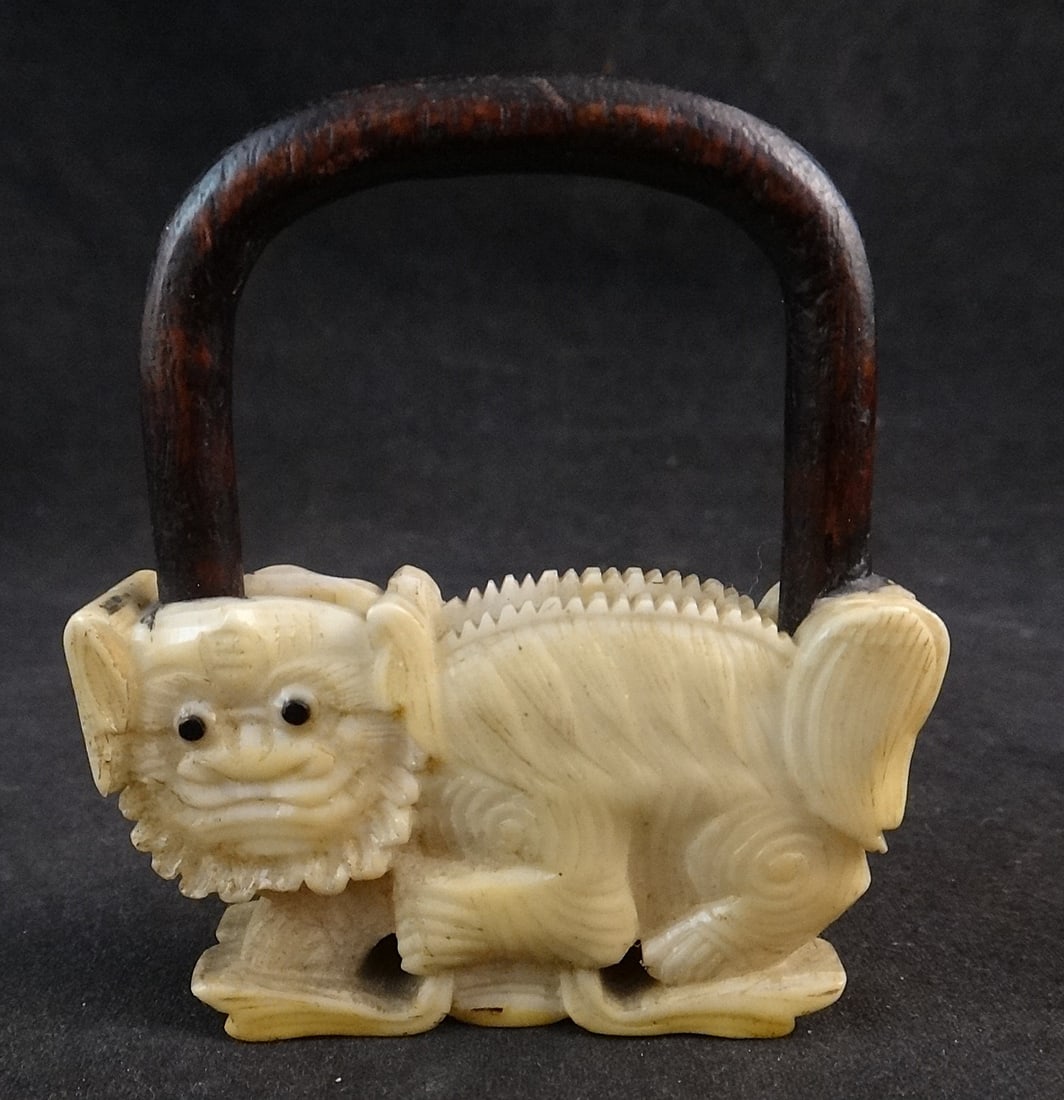 Antique Chinese Carved Fan Ornament in the form of Foo Dog. c.1820.: Antique Chinese Carved Fan Ornament in the form of a Foo Dog. Circa 1820. Newer carved rosewood base and handle. Overall measures 2 1/8” wide x ½” deep x 2 ½” tall.
