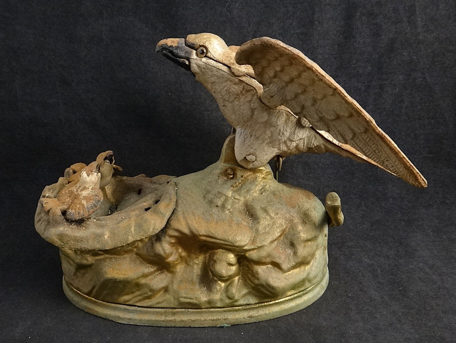 1970’s Cast Iron Mechanical Bank of a Mother Eagle with 2 Eaglets: 1970’s Cast Iron Mechanical Bank of a Mother Eagle with 2 Eaglets in a nest originally produced by J&E Stevens Co. A branch is pulled down & the mother drops the coin into the nest which has a slot
