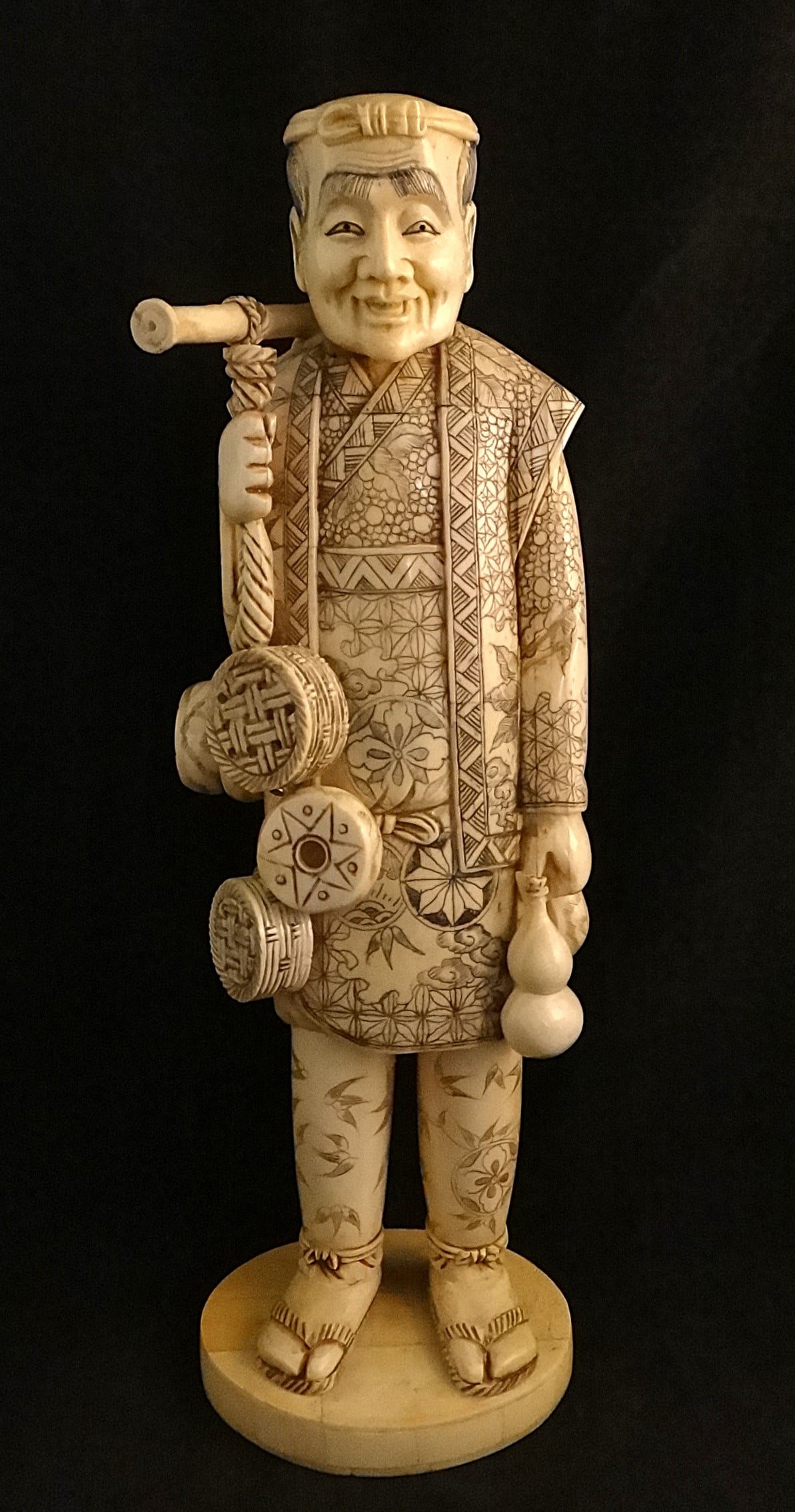 Lg. Antique Japanese Carved Basket Seller w/decorated robe & many baskets.: Large Antique Japanese Carved Basket Seller wearing a decorated robe, carrying many baskets. Meiji period (1868-1912). Measures 12 ½” tall, base is 3 ¾” x 3”.