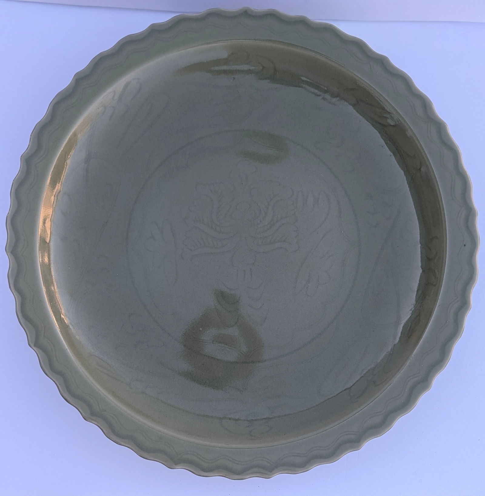 Exceptional Chinese Ming Dynasty Longquan Celadon Glaze Porcelain Charger: Exceptional Large Chinese Ming Dynasty Longquan Celadon Glaze Porcelain Charger with an incised lotus flower & incised border rim. 15th/16th cent. 16 ¼” dia. x 2 ½” tall.
