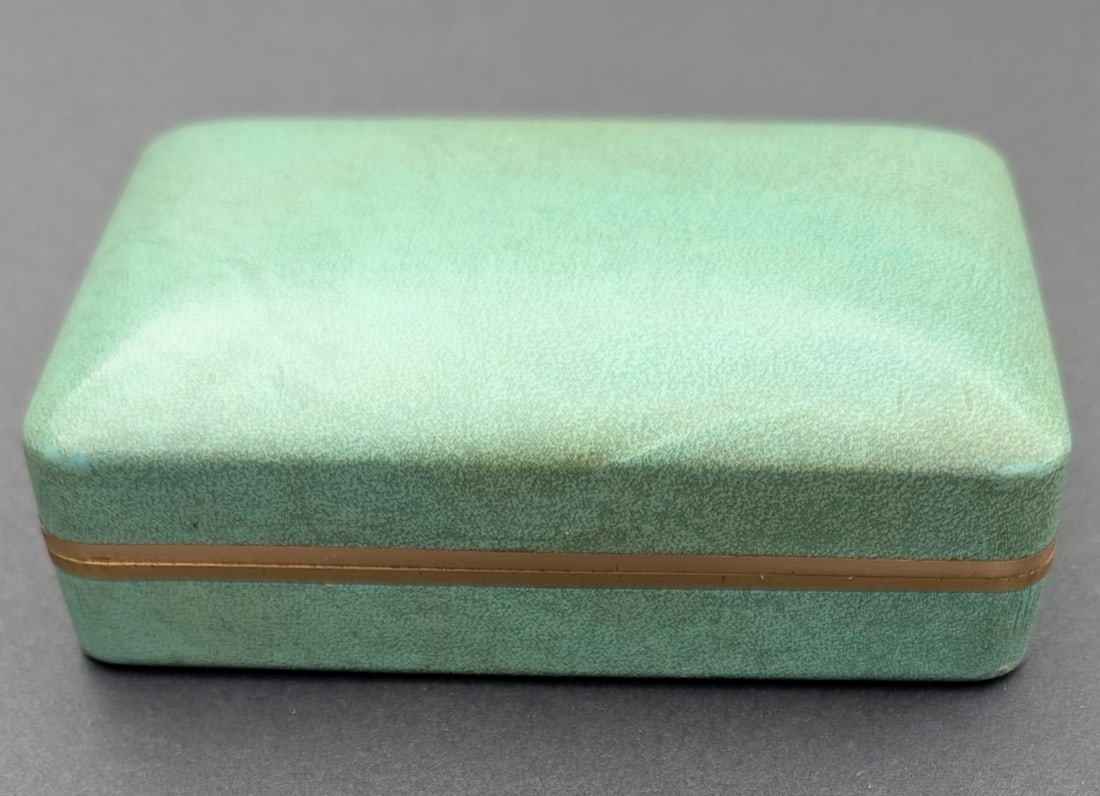 1950's Rolex Hard Case Watch Box w/Gold Metal Trim: 1950's Rolex Hard Case Watch Box in Green Cover with Gold Metal Trim. Gold ROLEX and Crown on interior back. Red ribbon printed - Tudor Oyster (can easily be removed). Hinge very strong. 5" wide x 3 1