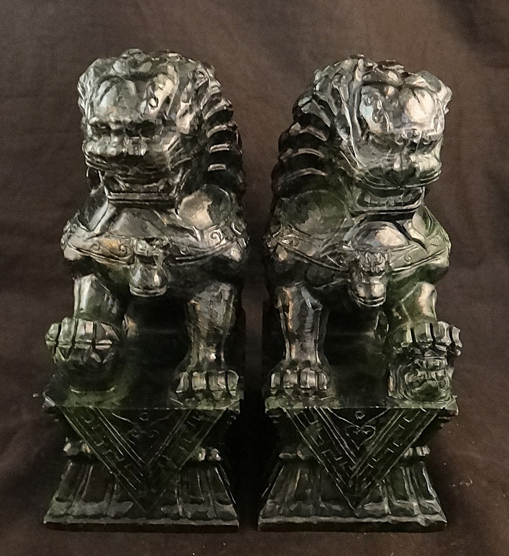 Pr. Vintage Chinese Carved Spinach Jade Mirror Image Foo Lions: Pair of Vintage Chinese Carved Spinach Jade Mirror Image Foo Lions on Attached Stands. 20th C. Measure 6 7/8” tall x 4 3/8” wide x 2 ¾” deep.