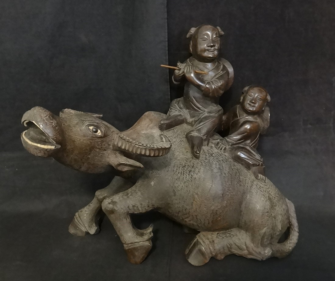 Antique Chinese Carved Rosewood Water buffalo w/ 2 Boys: Antique Chinese Carved Rosewood Water buffalo with 2 Boys on Top, one playing the flute. Guangxu period – 1875-1908. Measures approx. 16” t. x 18” w. x 14” deep. Weighs 17 lbs.