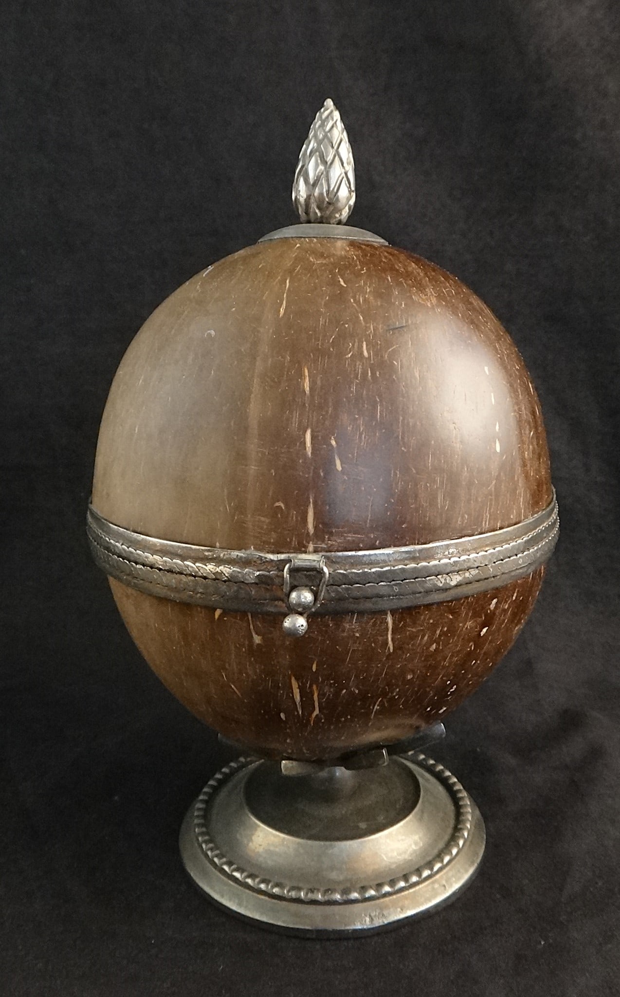 Antique Silver-Mounted Coconut Shell Hinged Box: Antique Silver-Mounted Coconut Shell Hinged Box with Silver Pineapple Shaped Finial & Round Base with Beaded Trim. Early 20th cent. Measures 7 ¼” tall x 4 3/8” dia. No hall marks, p
