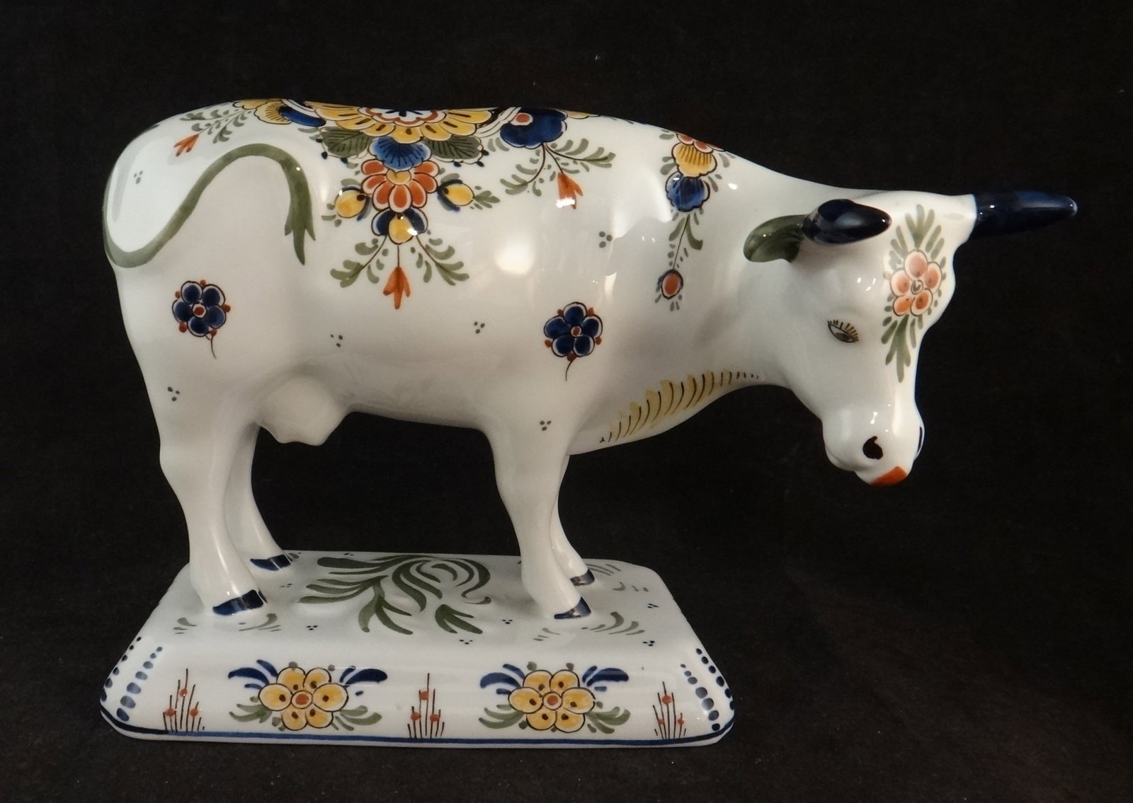 Antique Dutch Delft Pottery Cow w/floral designs.: Antique Dutch Delft Pottery Cow with finely hand painted floral designs. Signed on the bottom in blue. Early 20th cent. 8 ½” long x 6 ¼” tall x 3 ¼” wide.