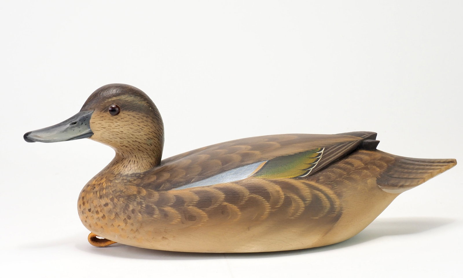 George Strunk - Blue Wing Teal Hen: George Strunk (b.1958) Glendora, NJ 12" long Premier raised and crossed wing design with a slightly turned and lifted head. Glass eyes with a nicely carved bill and rasped head. Carved tail feathers.