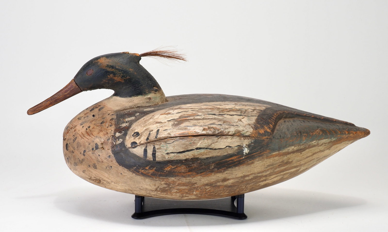 Reggie Birch - Merganser Drake: Reggie Birch (b. 1953) Chincoteague, VA 8.75" across | 18" Bold merganser with deeply relief carved back, carved eyes, and horse hair crest. Inletted head, R Birch and 'R' deeply carved into the botto