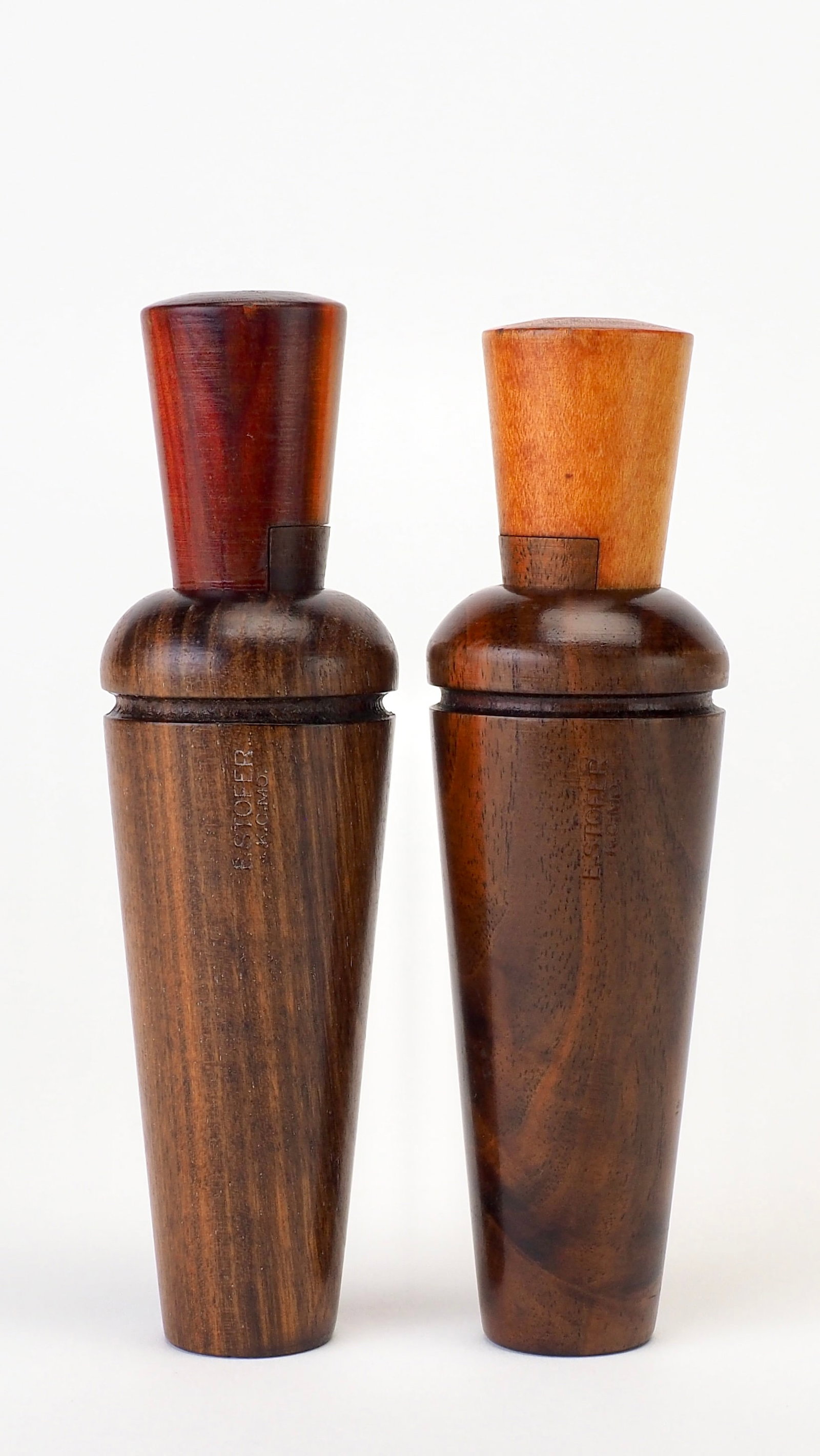 Two E.S. Stofer Duck Calls: E.S. Stofer (1886-1958) Kansas City, MO 5.75" E. Stofer KCMO stamped on side of barrels. One burled and one regular. Burled call has matching number 44 insert and wedge block Though little is known ab
