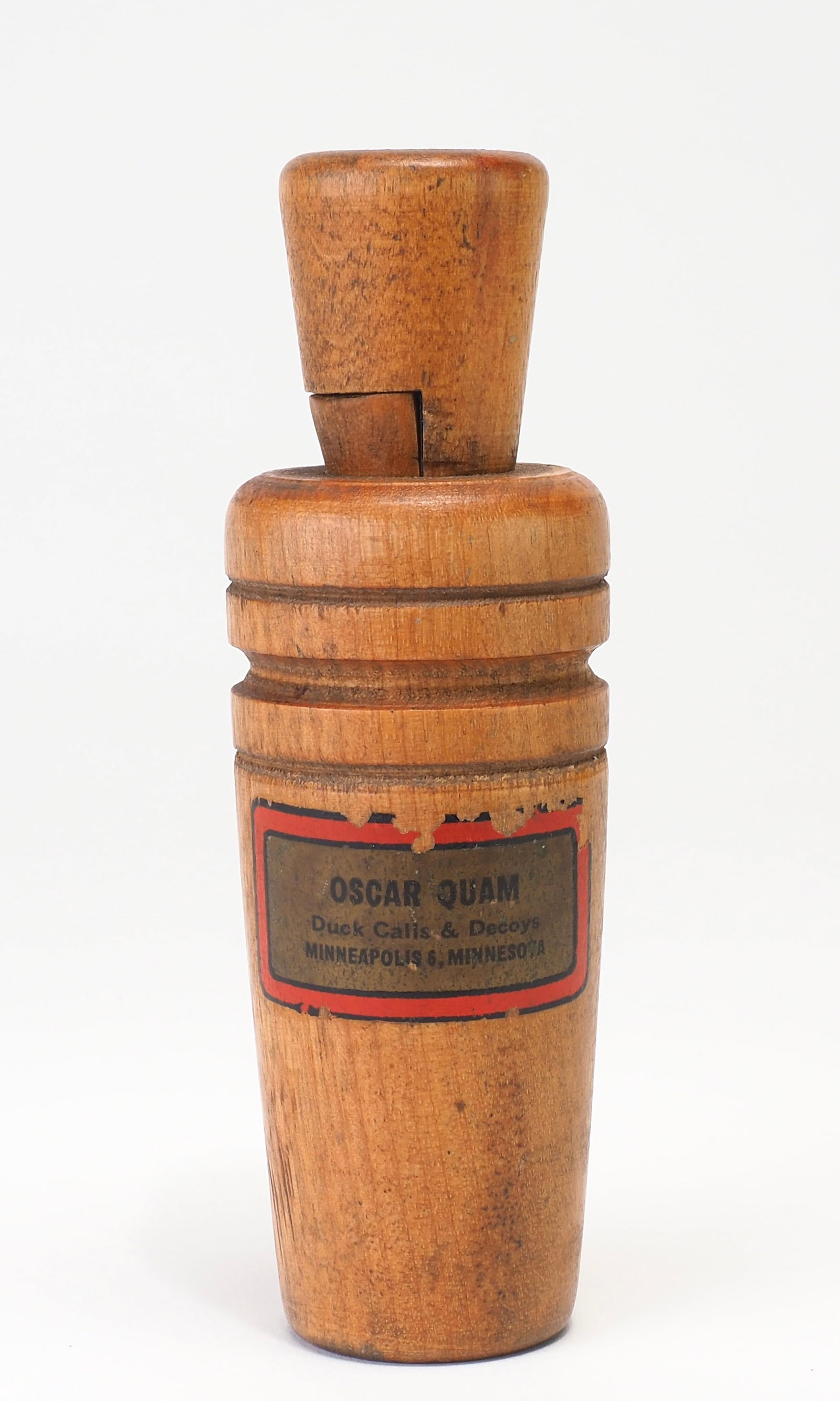 Oscar Quam - Smooth Barrel Duck Call: Oscar Quam (1887-1969) Minneapolis, MN 4.75" long Oscar Quam graphic on barrel Condition: Very good and original with light wear from use. Sliver of wood missing from back side of barrel with minor