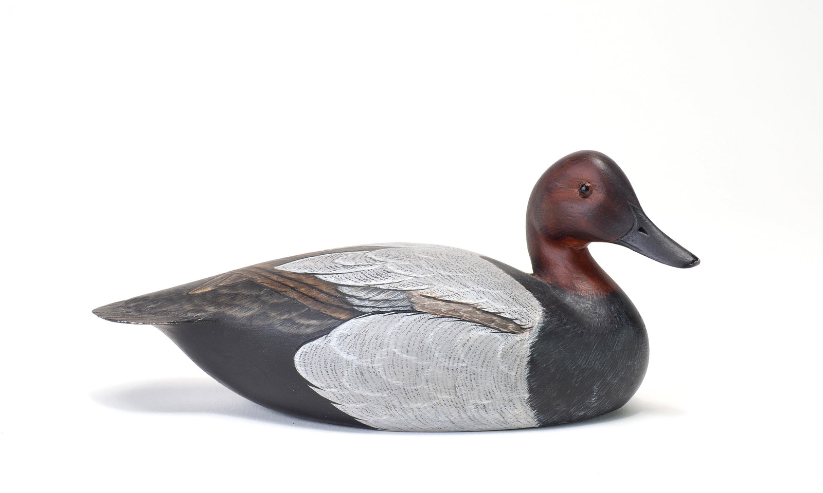 Ken Harris - Miniature Canvasback Drake: Ken Harris (1905-1981) Woodville, NY Roughly 7" long Head is turned to the right with glass eyes and incised bill details. Some incised feathering on the back. Painter initials 'PD' on the underside.