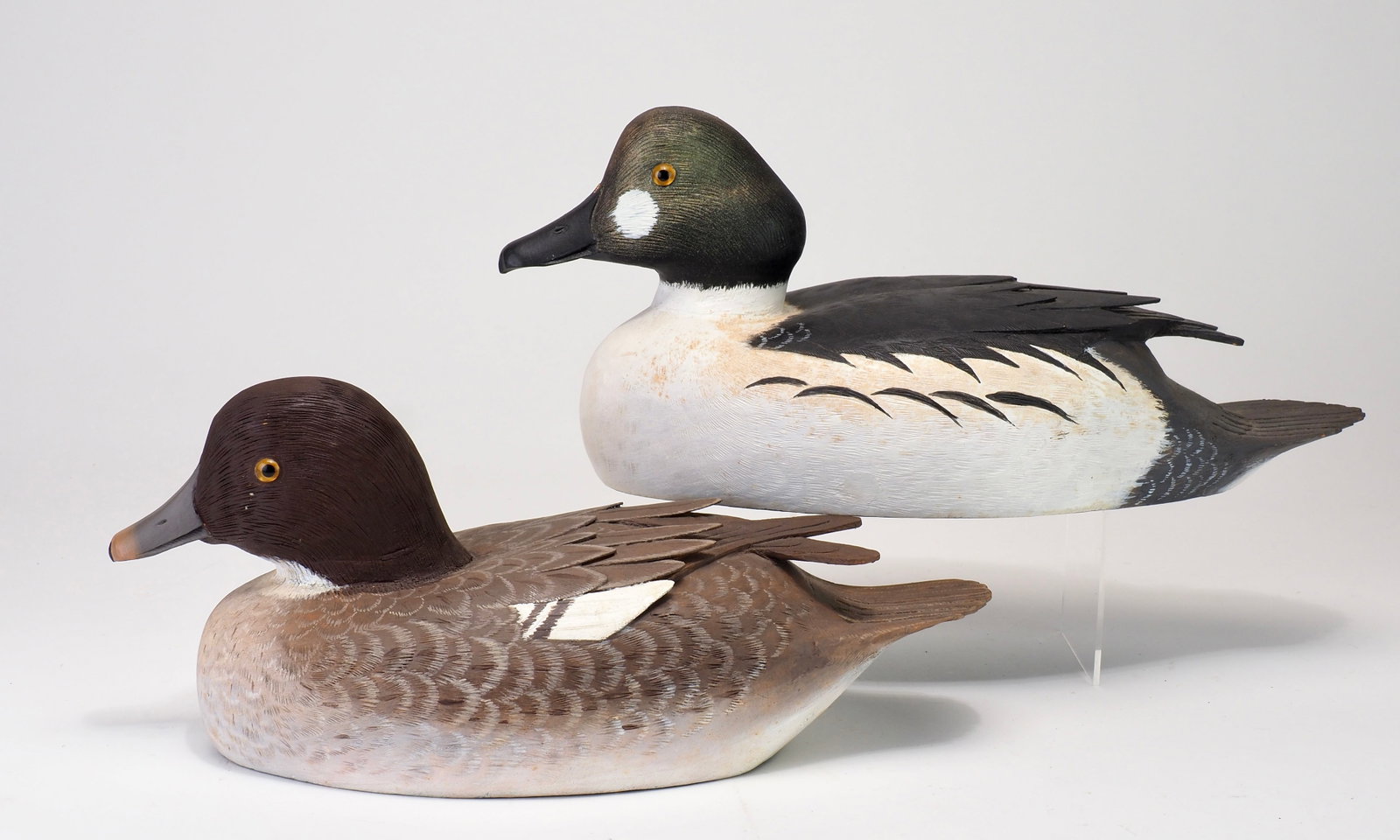Reg Bloom - Decorative Goldeneye Pair: Reginald T. Bloom (1916-2005) Kingston, Ontario, Canada c.1970s 12.5" Hen | 14" Drake Rare highly decorative carvings by Bloom. Raised and crossed wing tips with carved feathering and bill details.