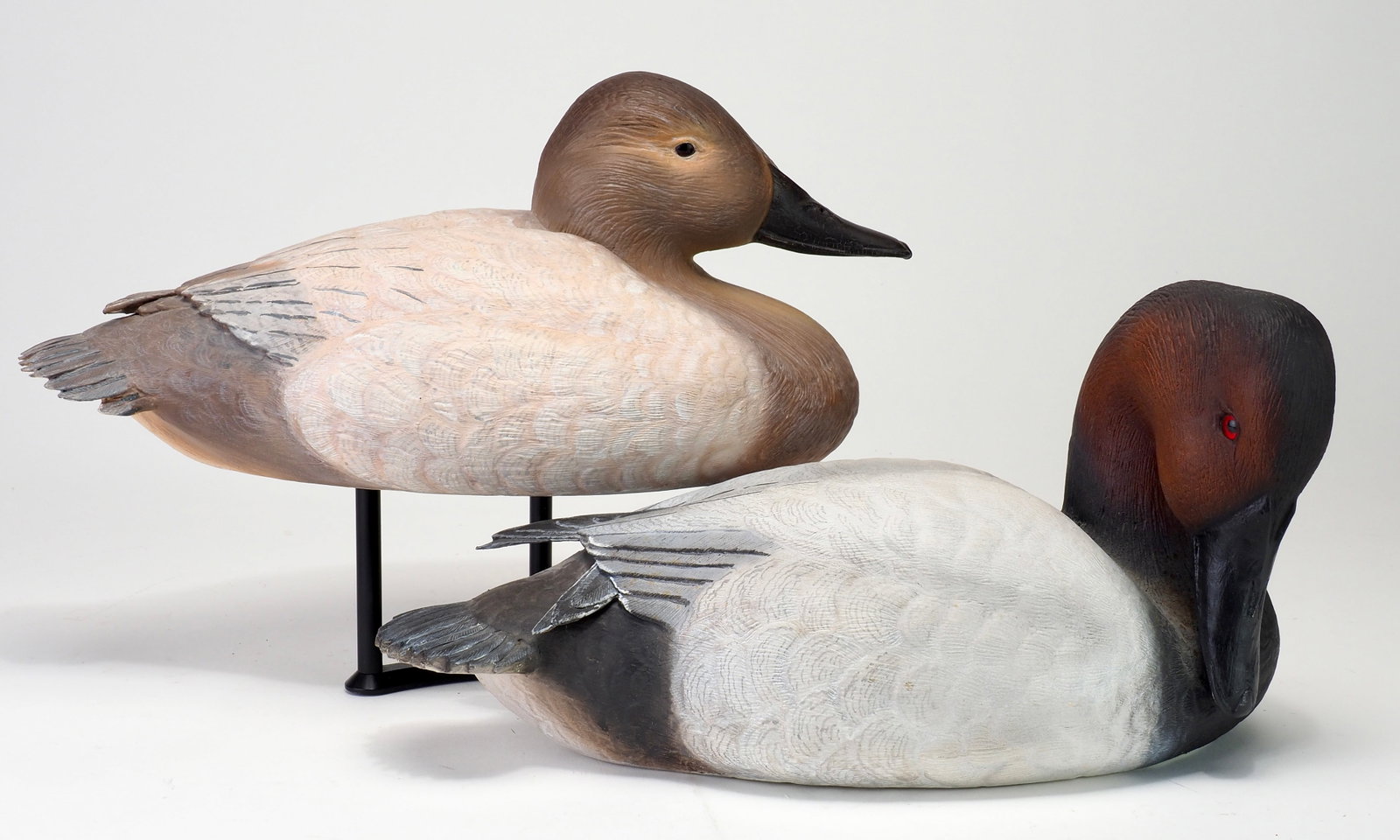 Jon Foster - Canvasback Pair: Jon Foster Canada c.1970 Hen 14" long | Drake 13.5" long Hollow carved with feather carved details across the bodies and raised primary wing tips. Signed and dated 1970 Condition: Very good and