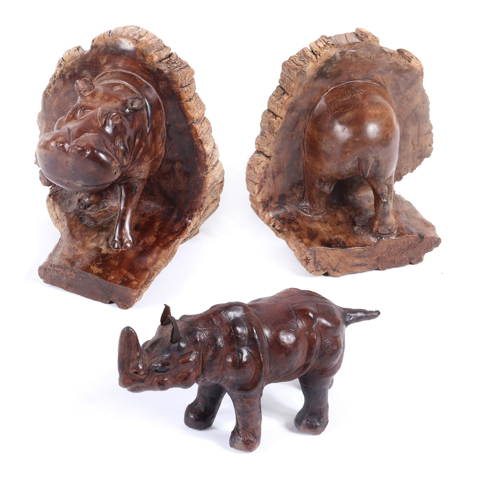 Pair African hand carved natural wood bookends in the: Pair African hand carved natural wood bookends in the form of a 3 dimensional rhinoceros front and back along with a leather covered animal figure.7"H x 6"W x 5 1/2"D (one bookend).