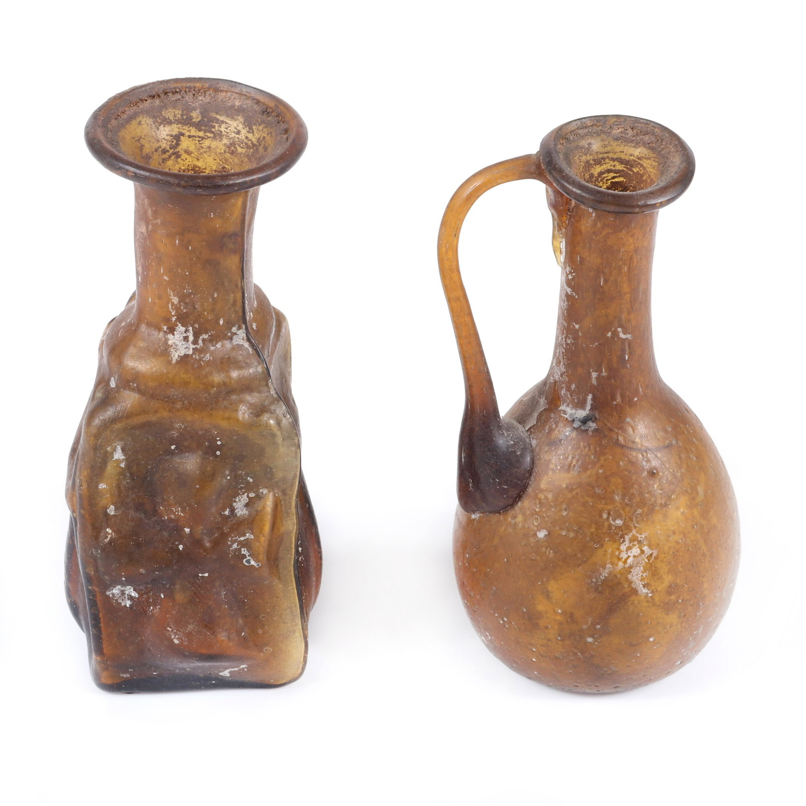 Two ancient Roman glass vessels: Byzantine bottle with: Two ancient Roman glass vessels: Byzantine bottle with dross design, ca 700 A.D. and amber glass handled jar, ca 50-100 A.D., 4"H (cross), 4"H (handle)