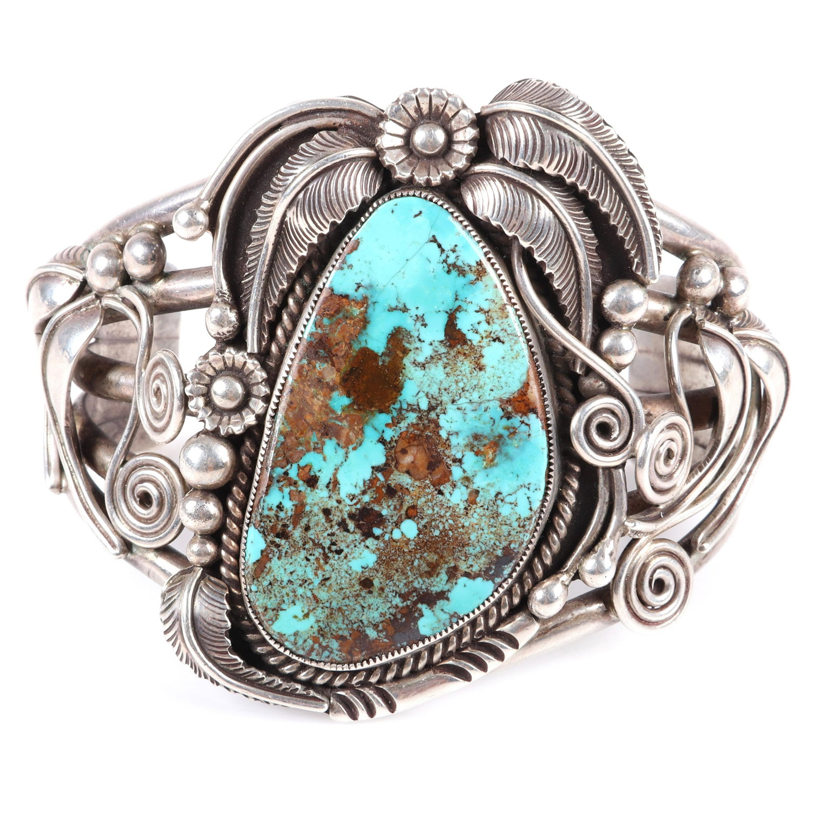 Paul Cayatineto Navajo Native American Indian sterling: Paul Cayatineto Navajo Native American Indian sterling silver layered, heavily-tooled, floral hammer work cuff bracelet with Huge 1 3/4"H turquoise central stone. Inscribed Paul Cayateneto. 2 1/2"inne