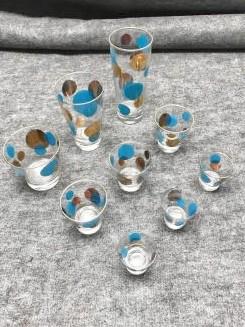 Russel Wright Eclipse Nine Piece Lot of Glassware-Blue: Russel Wright Eclipse Nine Piece Lot of Glassware-Blue with Gold Moons: One Zombie; One Highball; One Old-fashioned; Three Cocktails; Three Shot Glasses. Wear to gold rims and some moons. 7"H (tallest
