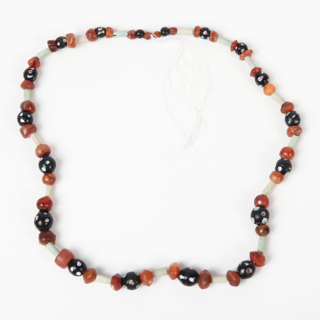 Strand of Persian tomb / trade beads, millefiore glass,: faience, and carnelian. 23"L Provenance: from Taylor University's Dr. Neil and Mrs. Renee Compton Collection. Proceeds benefit Taylor University endowed scholarship funds.