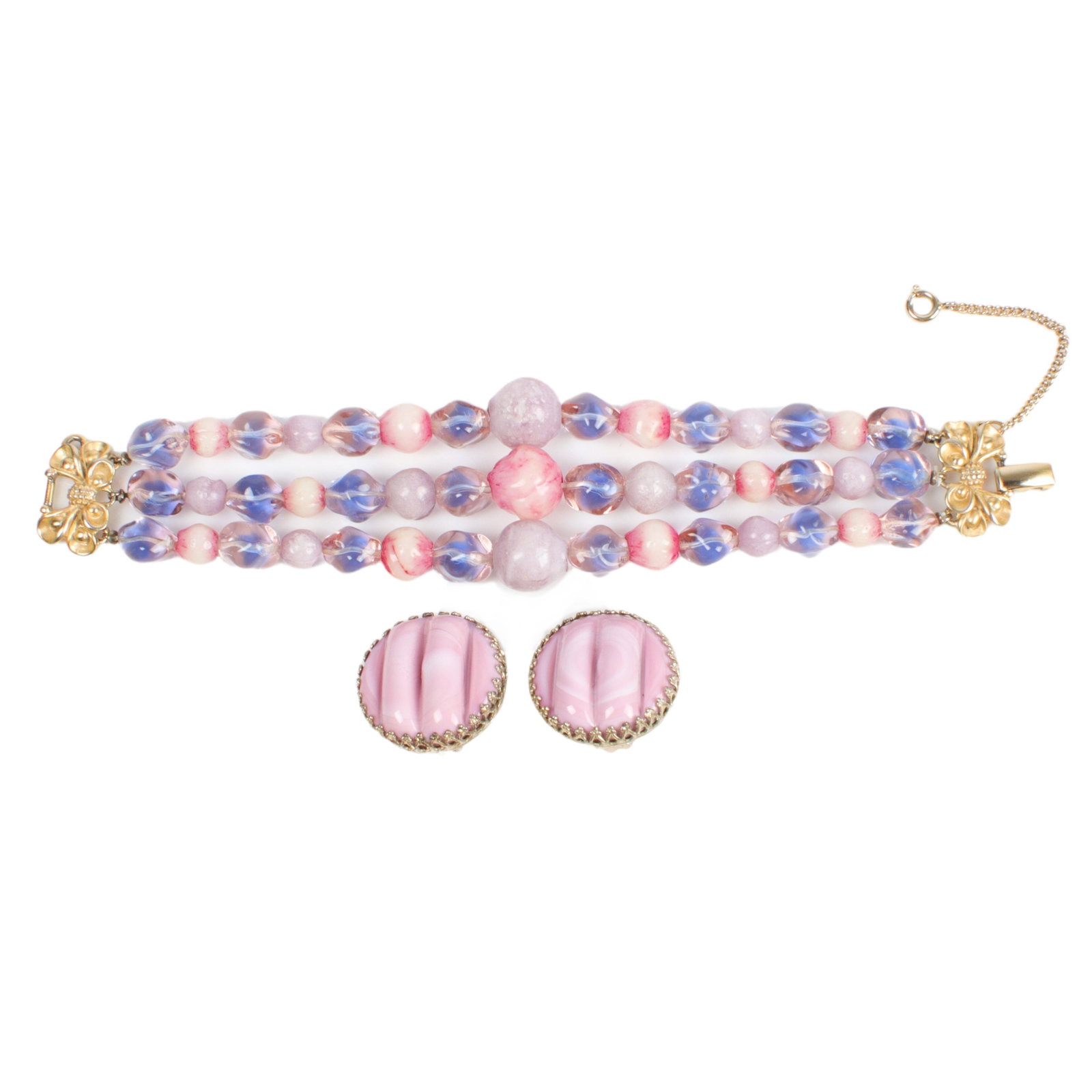 Schiaparelli 3-strand bracelet with pink opaque and clear molded glass beads: 7 1/2"L, 1 1/2"W: Schiaparelli 3-strand bracelet with pink opaque and clear molded glass beads: with decorative gold tone ribbon clasp and coordinating Schiaparelli molded glass button earrings. 7 1/2"L, 1 1/2"W