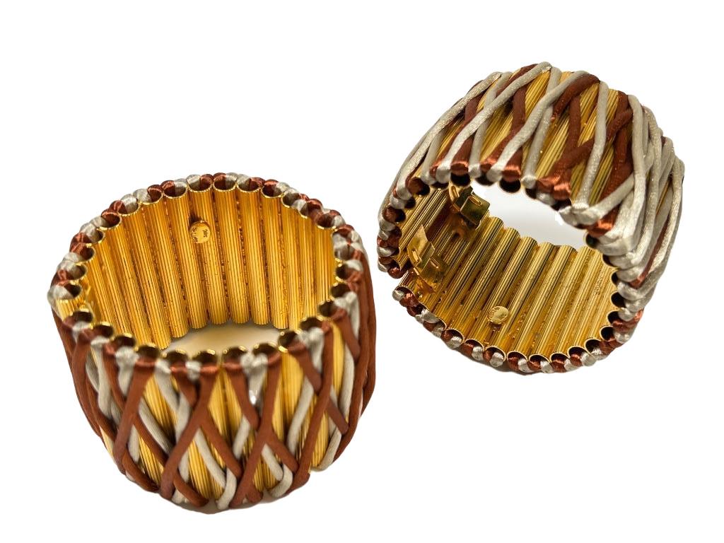 Pair of William DeLillo fused gilt tube clamper cuff bracelets wrapped in rust & cream silk cord. 2: Pair of William DeLillo fused gilt tube clamper cuff bracelets wrapped in rust & cream silk cord. 2 1/4" inner W x 2"W