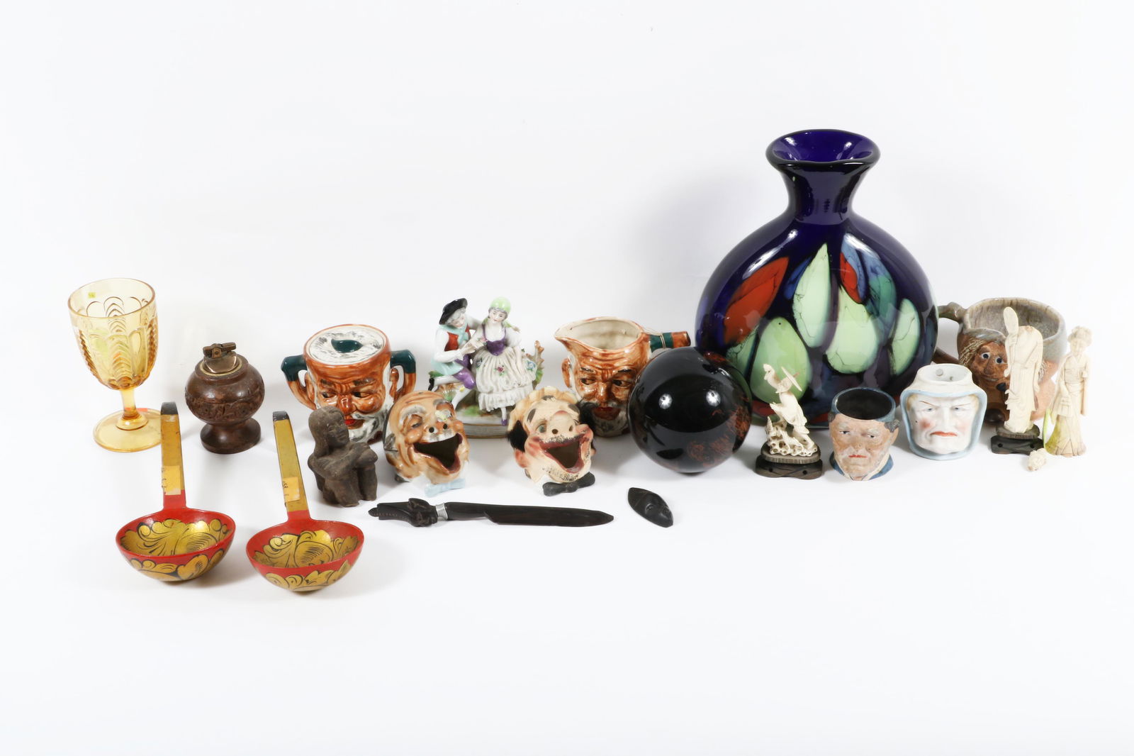 Lot of 20 decorative objects: including 5 figural head mugs, 2 Russian hand-painted ladles, 11"H x 8: Lot of 20 decorative objects: including 5 figural head mugs, 2 Russian hand-painted ladles, pink depression glass goblet, wooden lighter, African carved letter opener, 3 Chinese carved soapstone figur