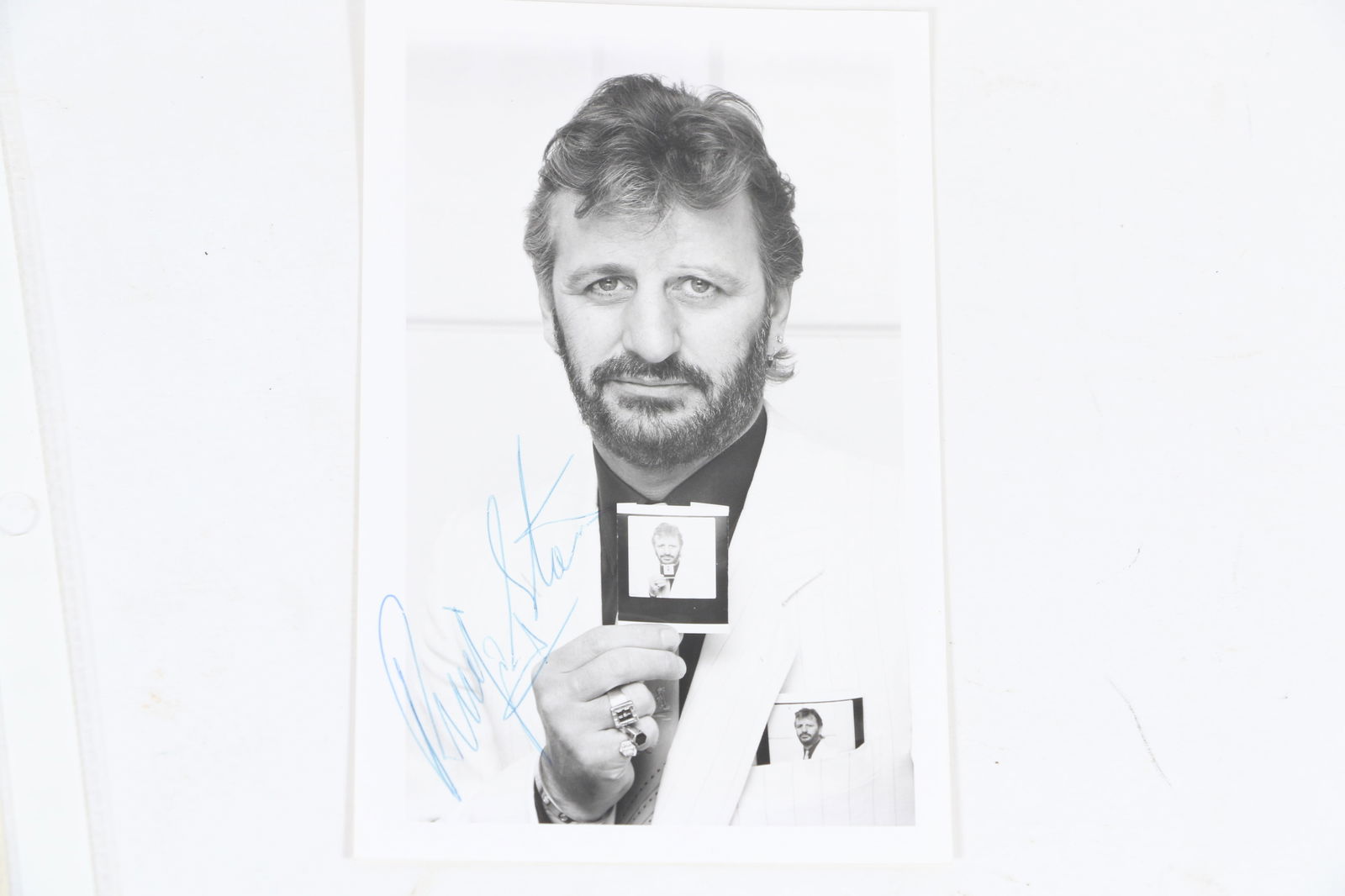 Ringo Starr Autographed Photo: Ringo Starr Autographed Photo The photo is a 3 1/2 by 5 1/2 photo of Ringo holding a photo of himself. COA from RR Auctions