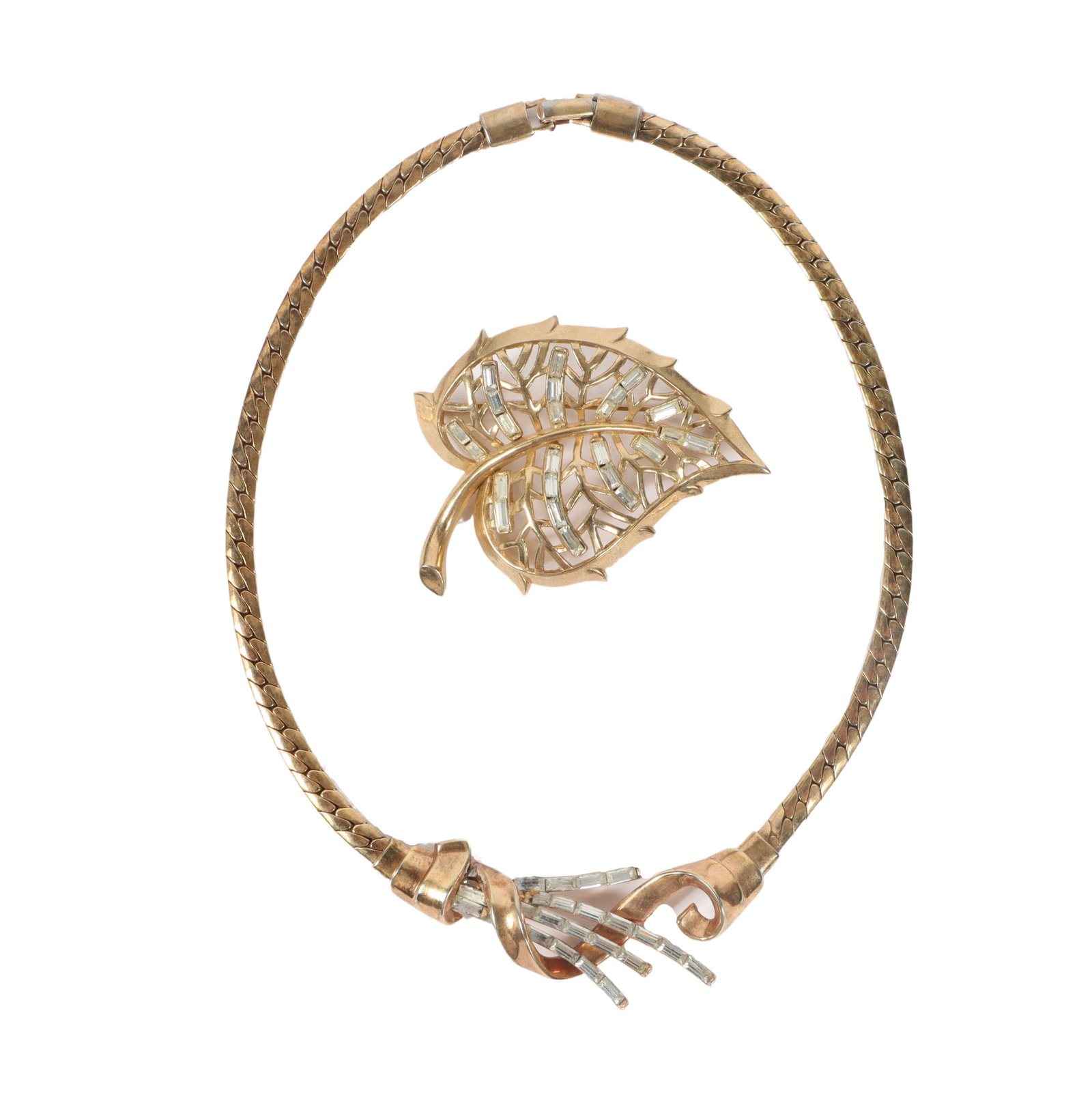 Vintage Trifari 2pc. Retro gold wash costume jewelry group; scrolling baguette diamante spray: Vintage Trifari 2pc. Retro gold wash costume jewelry group; scrolling baguette diamante spray necklace with and leaf pin brooch with reticulated openwork design. 15"L x 1"W (Necklace)