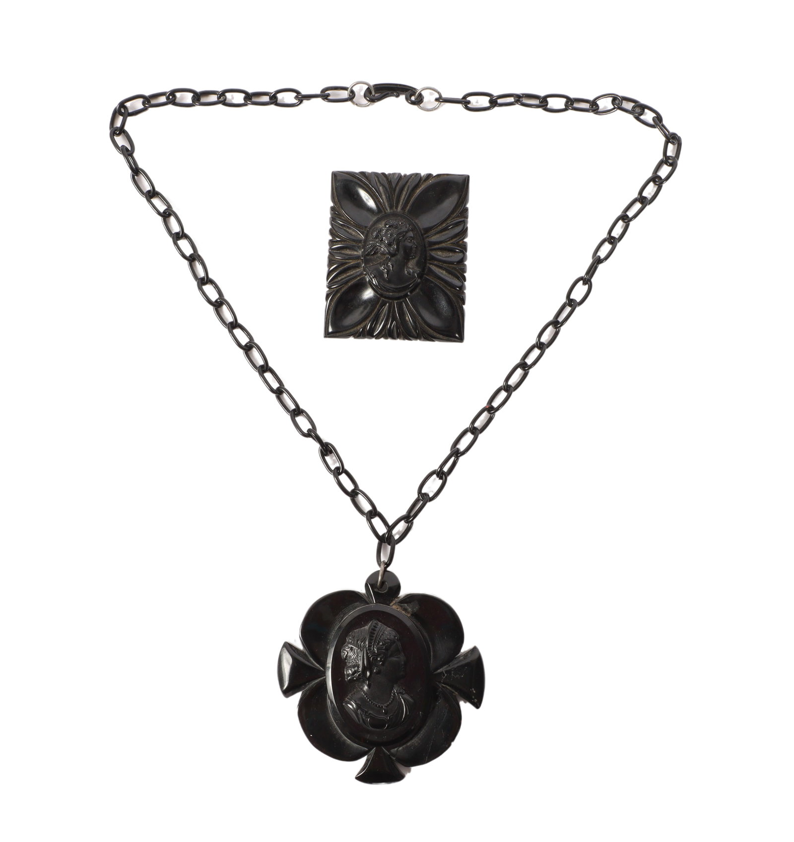 Black Bakelite cameo pendant with carved black Bakelite cameo pin brooch. 21"L x 3"W (necklace): Black Bakelite cameo pendant with carved black Bakelite cameo pin brooch. Cameo pendant has been repaired. 21"L x 3"W (necklace)