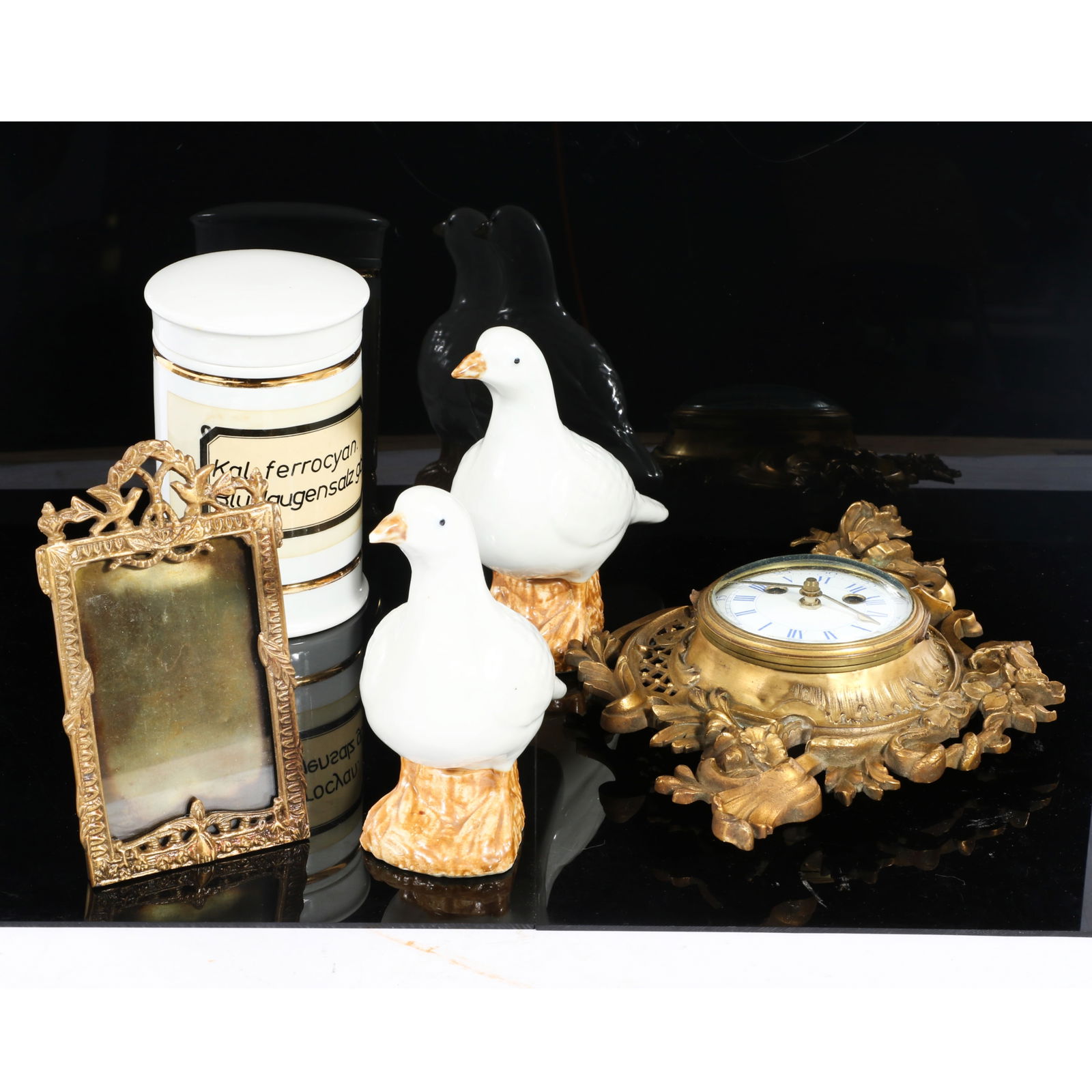 Collection of decorative objects: gilt bronze cartel wall clock, porcelain apothecary jar, 6 1/2"H x: Collection of decorative objects: gilt bronze cartel wall clock, porcelain apothecary jar, gilt metal easel back picture frame with bird motif, pair of Chinese export porcelain doves. Provenance: from