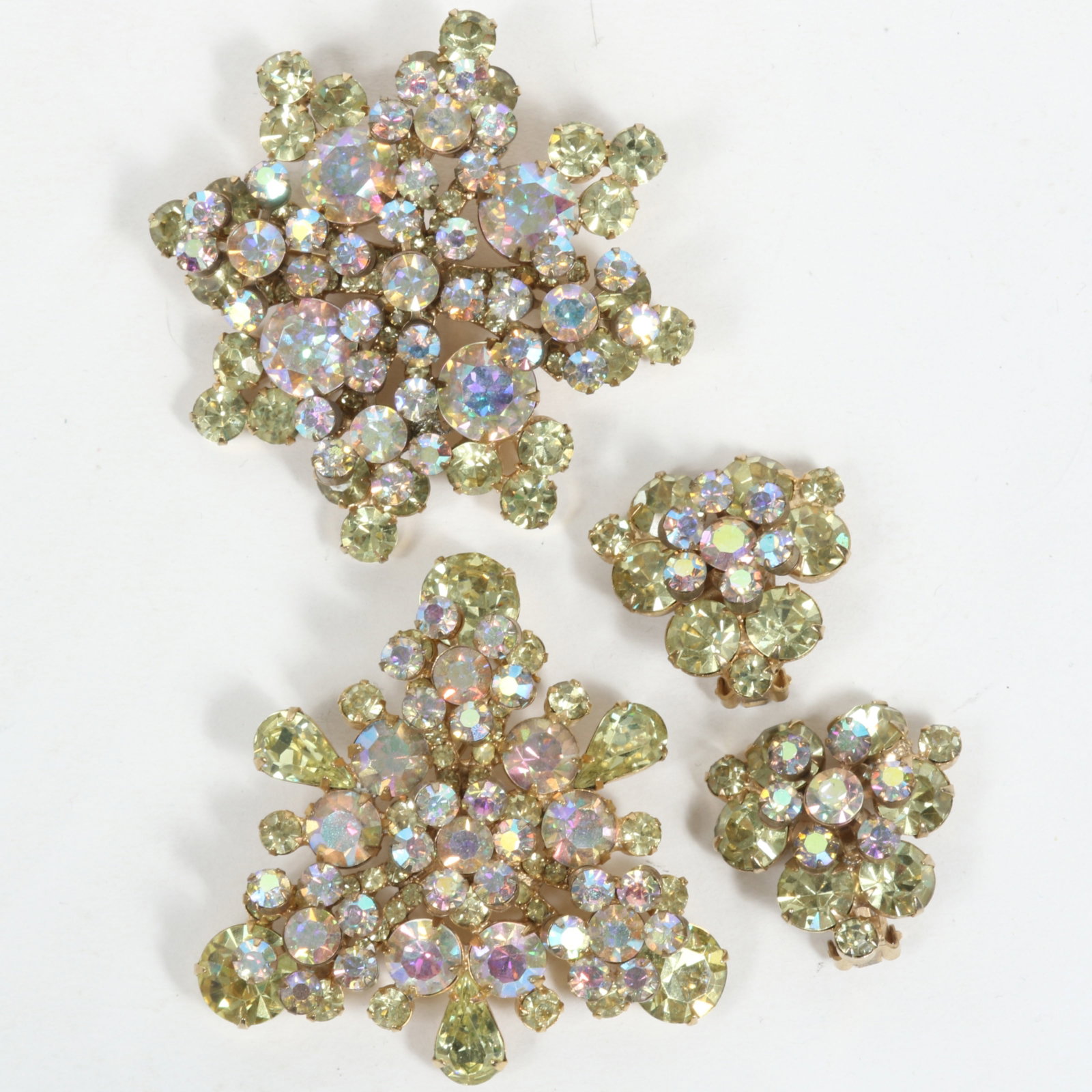 DeLizza & Elster Juliana pastel green and aurora borealis pair of brooches and matching earrings. 2: DeLizza & Elster Juliana pastel green and aurora borealis pair of brooches and matching earrings. Provenance: From the collection of Cheryl Killmer. 2 3/8"H x 2 3/8"W (triangular brooch)