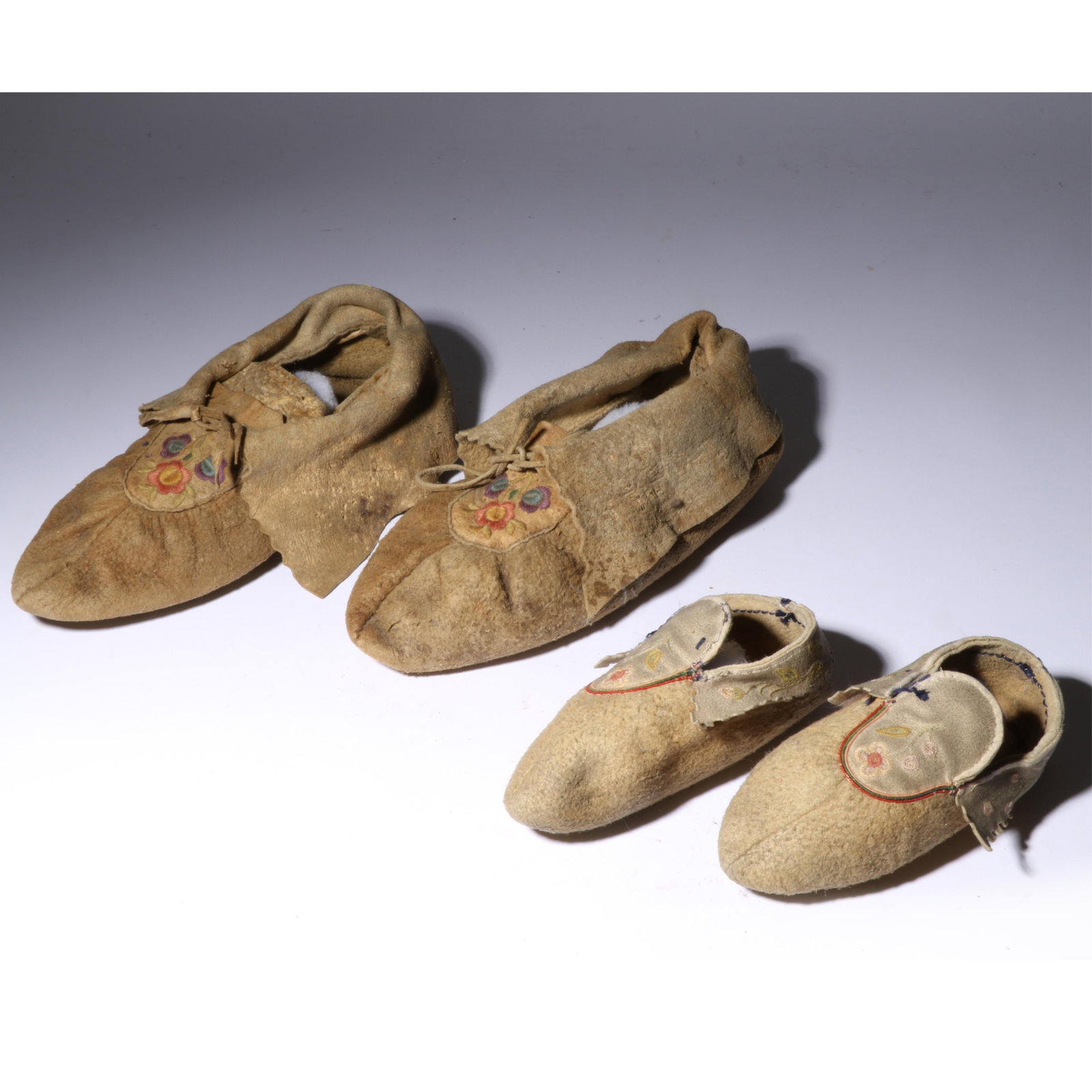 2 pairs Antique Woodland Pucker toe Moccasins with embroidery ca. early 1900s Pair 1: 11 3/4" long x: 2 pairs Antique Woodland Pucker toe Moccasins with embroidery ca. early 1900s Pair 1: Antique Woodlands Puckertoe adult moccasins w pink/purple/blue embroidered flowers ca. early 1900s 11 3/4" long x 